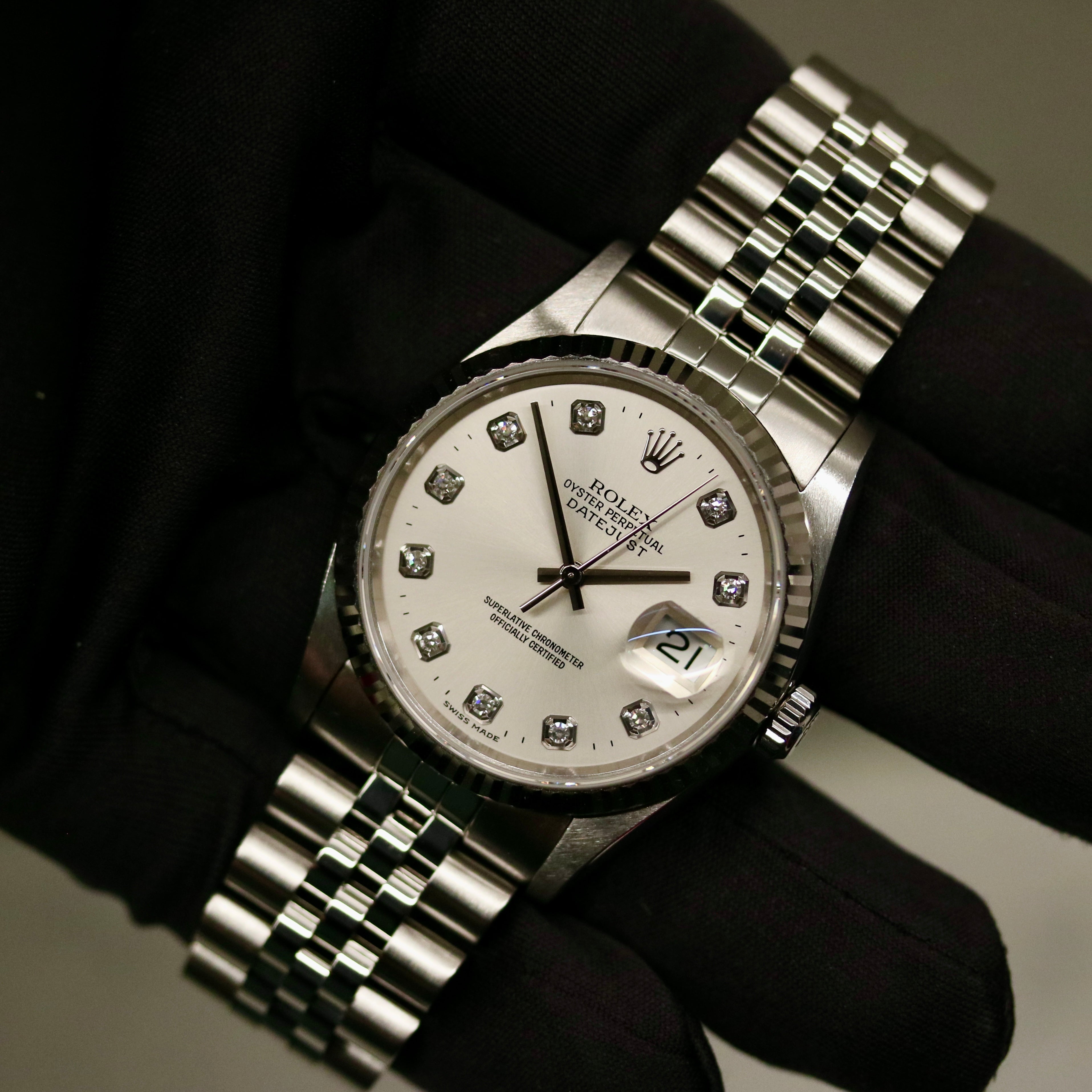 Rolex Datejust 36 ref. 16234 from 2000 with a white-gold fluted bezel and stainless-steel case and bracelet, featuring a factory silver diamond dial, sapphire crystal, automatic movement, and very good condition; detailed product images showing the dial, bezel, bracelet, case profile, and finishing, offered by Klocksalongen with recent polishing and 12-month functional warranty.