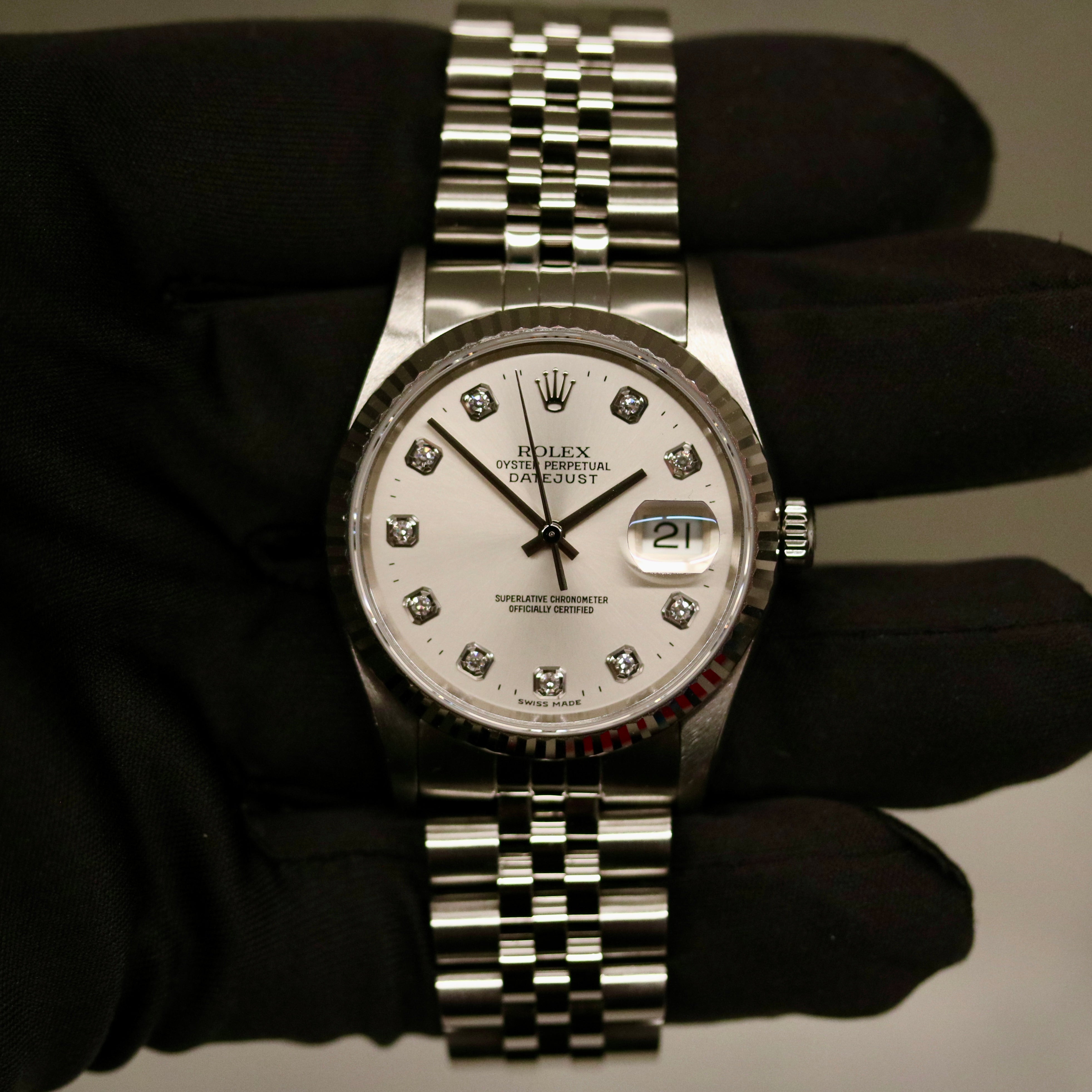 Rolex Datejust 36 ref. 16234 from 2000 with a white-gold fluted bezel and stainless-steel case and bracelet, featuring a factory silver diamond dial, sapphire crystal, automatic movement, and very good condition; detailed product images showing the dial, bezel, bracelet, case profile, and finishing, offered by Klocksalongen with recent polishing and 12-month functional warranty.