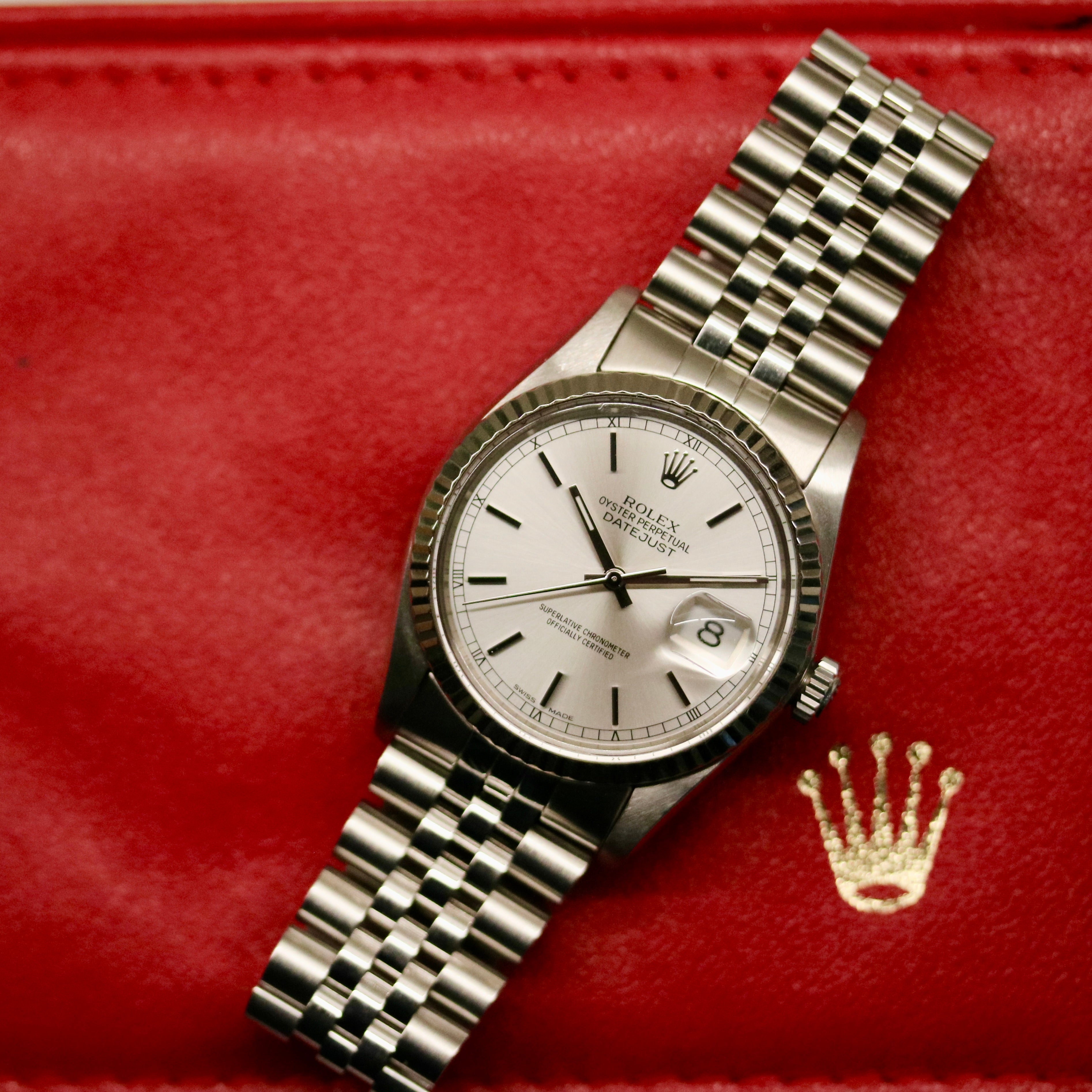 Rolex Datejust 36 ref. 16014 from 1984 with a white-gold fluted bezel and stainless-steel case and bracelet, featuring a silver dial, sapphire crystal, automatic movement, and very good condition; detailed product photos showing the dial, bezel, case profile, bracelet, and overall finishing, offered by Klocksalongen with authenticity certificate and 12-month functional warranty.