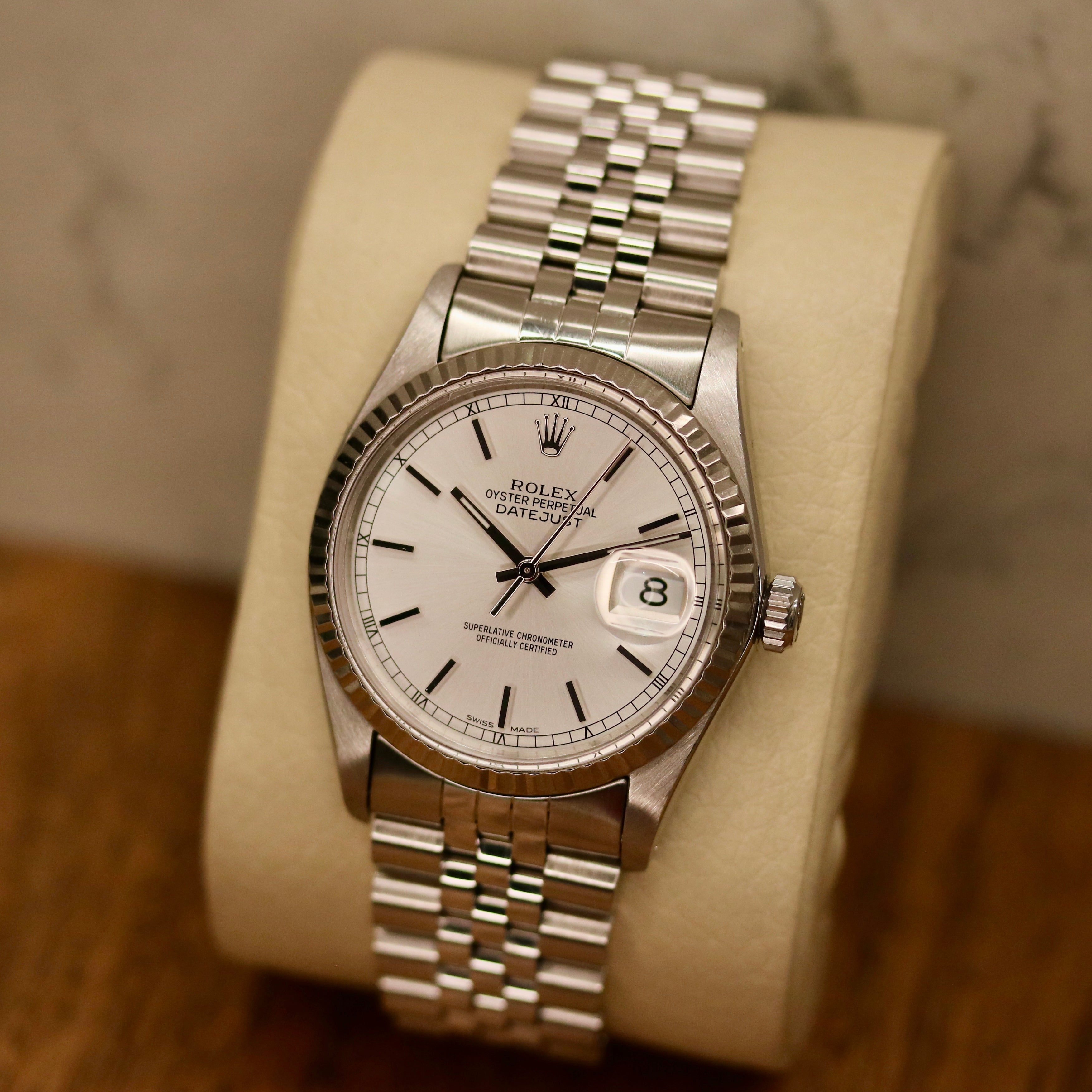 Rolex Datejust 36 ref. 16014 from 1984 with a white-gold fluted bezel and stainless-steel case and bracelet, featuring a silver dial, sapphire crystal, automatic movement, and very good condition; detailed product photos showing the dial, bezel, case profile, bracelet, and overall finishing, offered by Klocksalongen with authenticity certificate and 12-month functional warranty.
