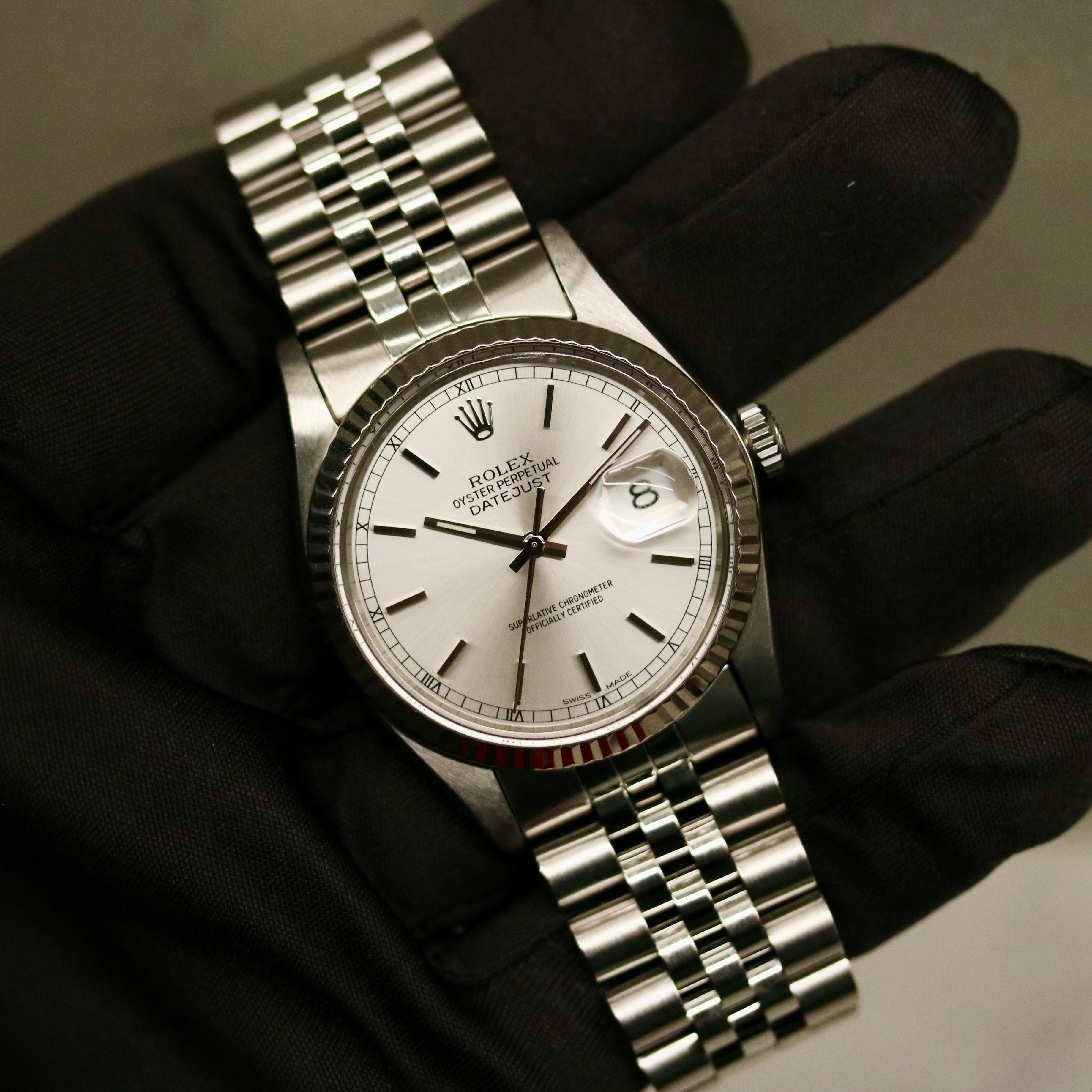 Rolex Datejust 36 ref. 16014 from 1984 with a white-gold fluted bezel and stainless-steel case and bracelet, featuring a silver dial, sapphire crystal, automatic movement, and very good condition; detailed product photos showing the dial, bezel, case profile, bracelet, and overall finishing, offered by Klocksalongen with authenticity certificate and 12-month functional warranty.