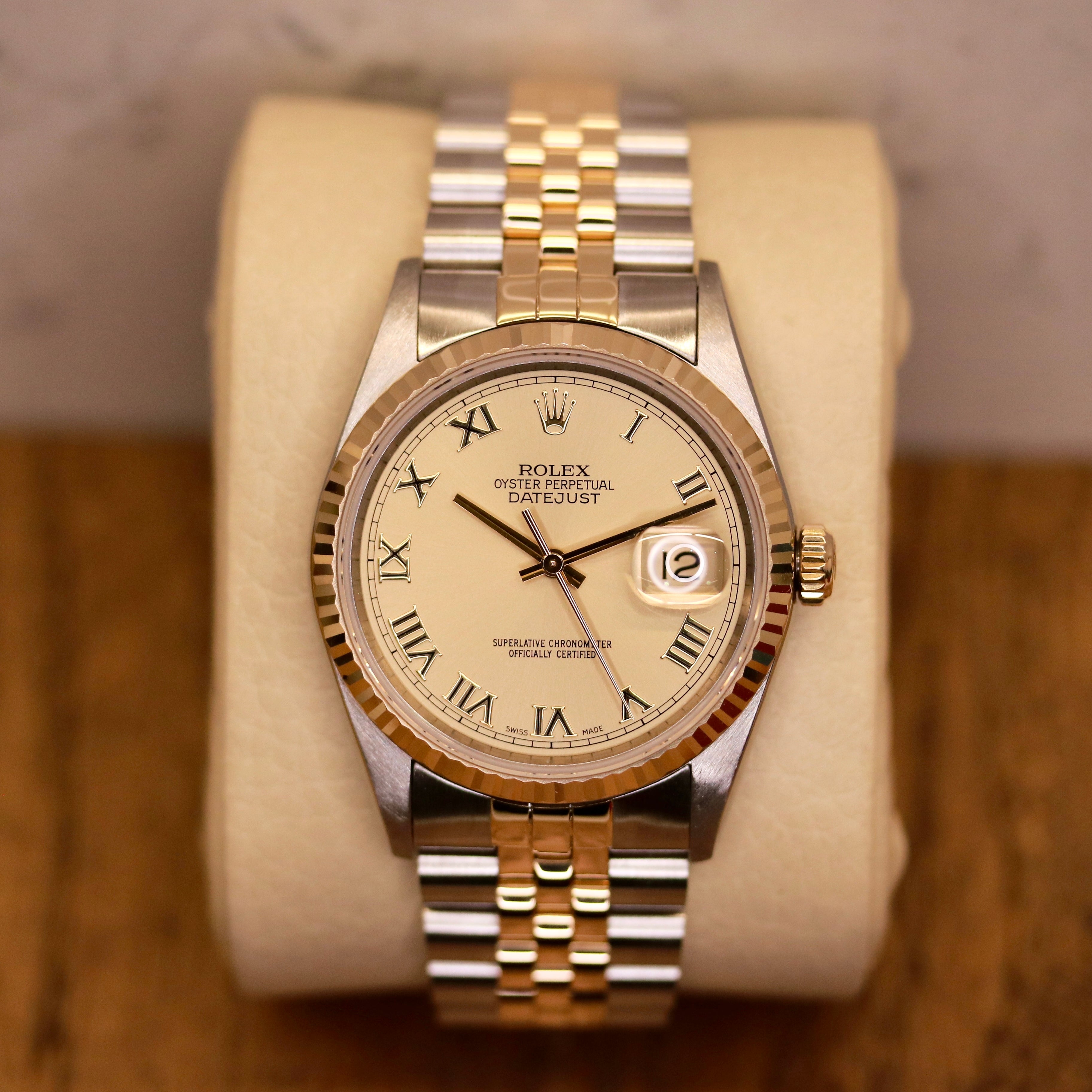 Rolex Datejust 36 ref. 16233 from 2003 in two-tone steel and yellow gold with a champagne Roman numeral dial, 36mm case, Jubilee bracelet, sapphire crystal, and automatic movement. Detailed product photos showing the fluted yellow-gold bezel, Roman hour markers, bracelet links, clasp, and overall condition. Includes original Hong Kong 2003 certificate, box, and tag, offered by Klocksalongen with a 12-month functional warranty.