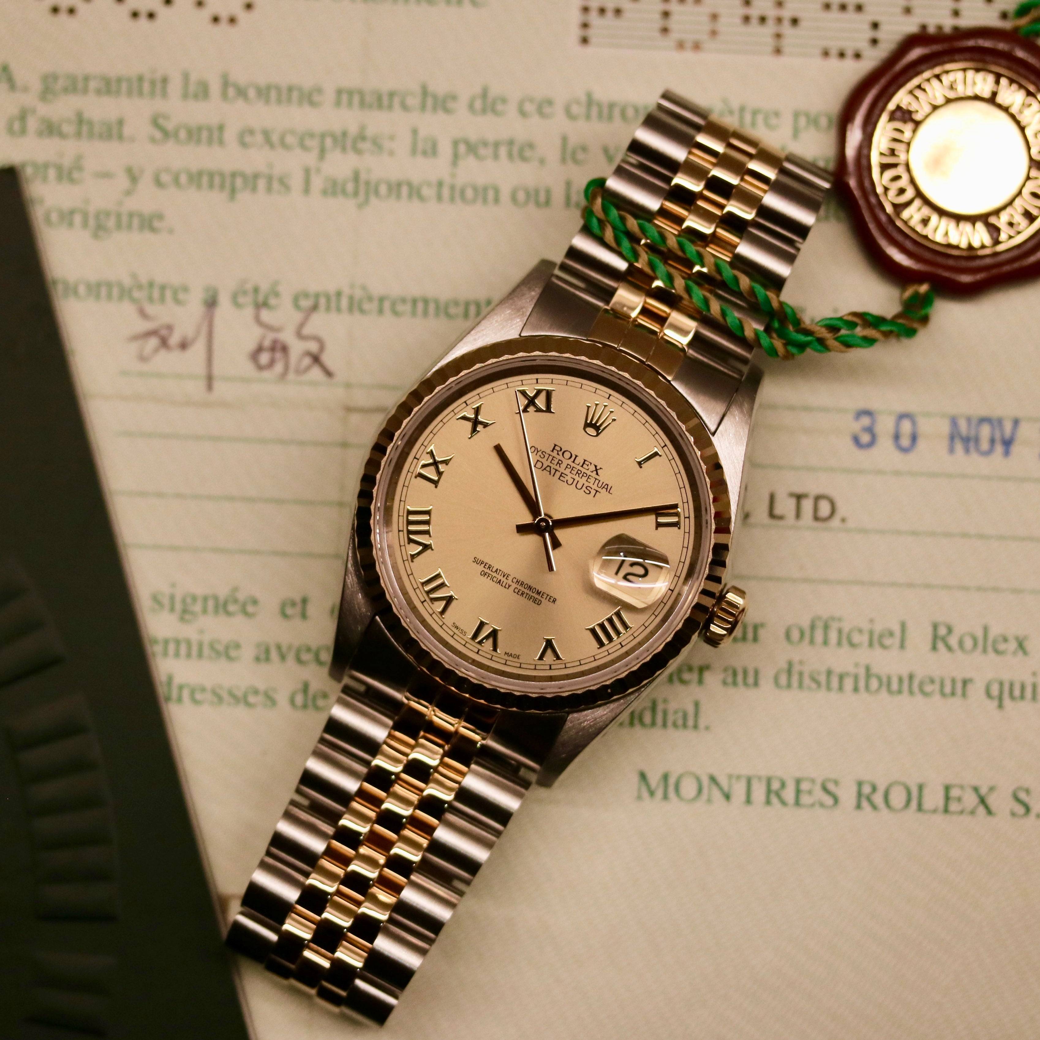 Rolex Datejust 36 ref. 16233 from 2003 in two-tone steel and yellow gold with a champagne Roman numeral dial, 36mm case, Jubilee bracelet, sapphire crystal, and automatic movement. Detailed product photos showing the fluted yellow-gold bezel, Roman hour markers, bracelet links, clasp, and overall condition. Includes original Hong Kong 2003 certificate, box, and tag, offered by Klocksalongen with a 12-month functional warranty.