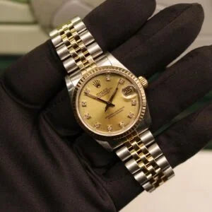Rolex Datejust 31 ref. 68273 from 1989 in two-tone stainless steel and yellow gold with a factory champagne diamond dial, 31mm case, Jubilee bracelet, sapphire crystal, and automatic movement. Freshly serviced and polished, in very good condition. Complete full set including original 1989 USA certificate, box, booklets, and tag. Detailed product photos showing the diamond-set dial, fluted bezel, case, bracelet, and clasp, offered by Klocksalongen with a 12-month service warranty.