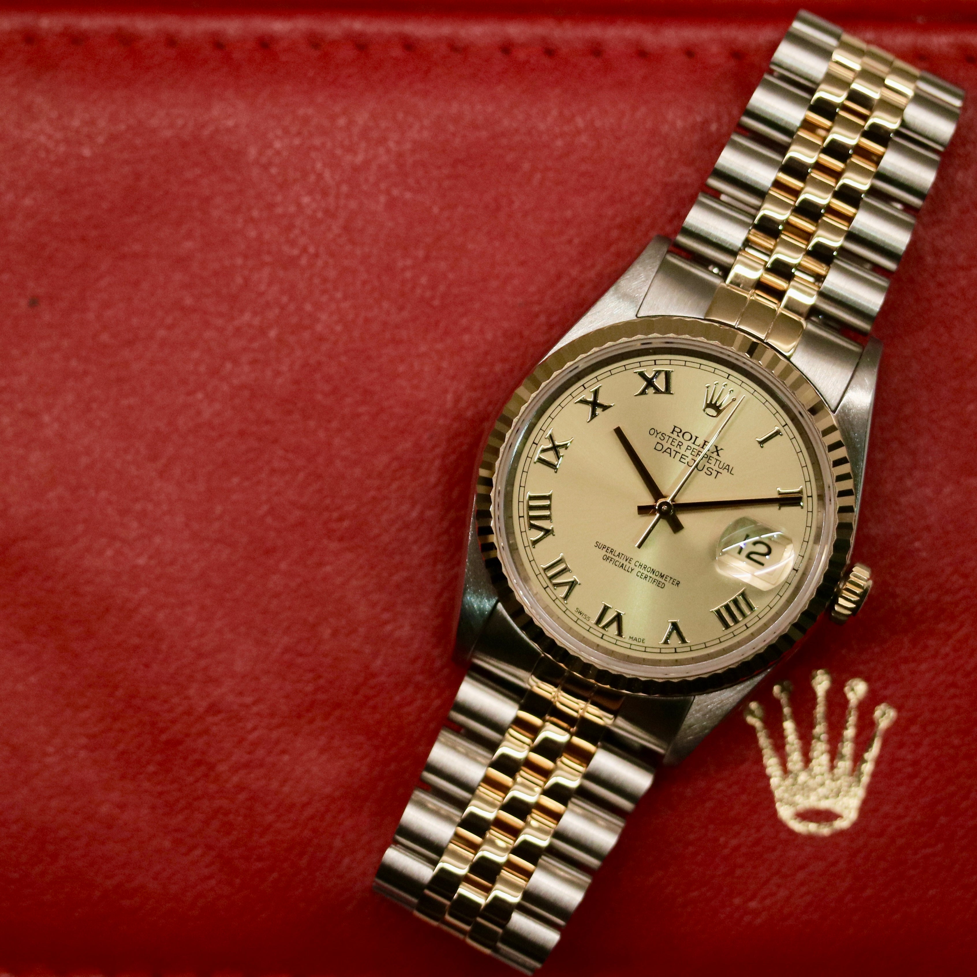 Rolex Datejust 36 ref. 16233 from 2003 in two-tone steel and yellow gold with a champagne Roman numeral dial, 36mm case, Jubilee bracelet, sapphire crystal, and automatic movement. Detailed product photos showing the fluted yellow-gold bezel, Roman hour markers, bracelet links, clasp, and overall condition. Includes original Hong Kong 2003 certificate, box, and tag, offered by Klocksalongen with a 12-month functional warranty.