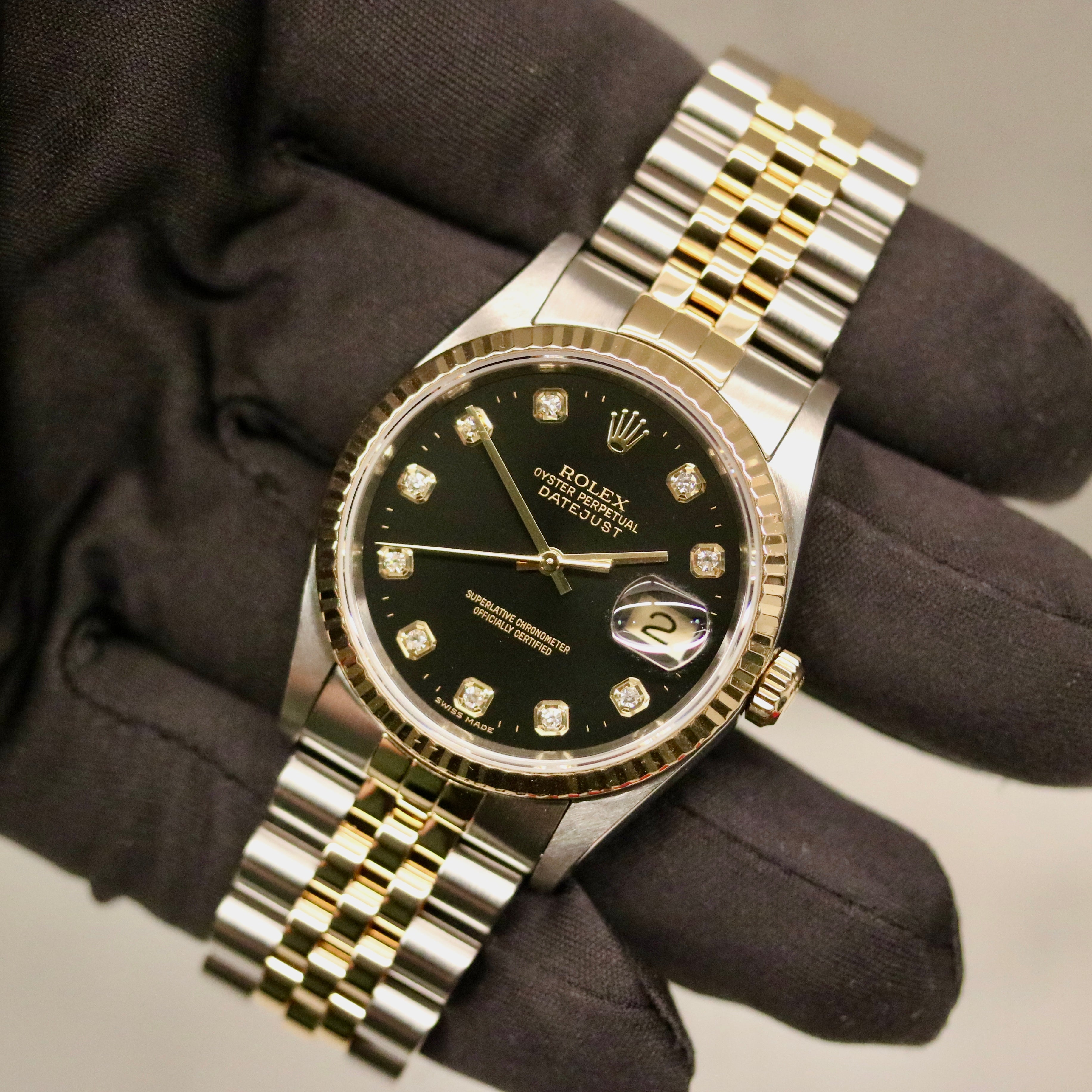 Rolex Datejust 36 ref. 16233 from 2000 in gold and steel with a factory black diamond dial, 36mm case, Jubilee bracelet, sapphire crystal, and automatic movement; detailed product photos showing the case, dial, bracelet, and overall very good condition, offered by Klocksalongen with polishing and 12-month functional warranty.