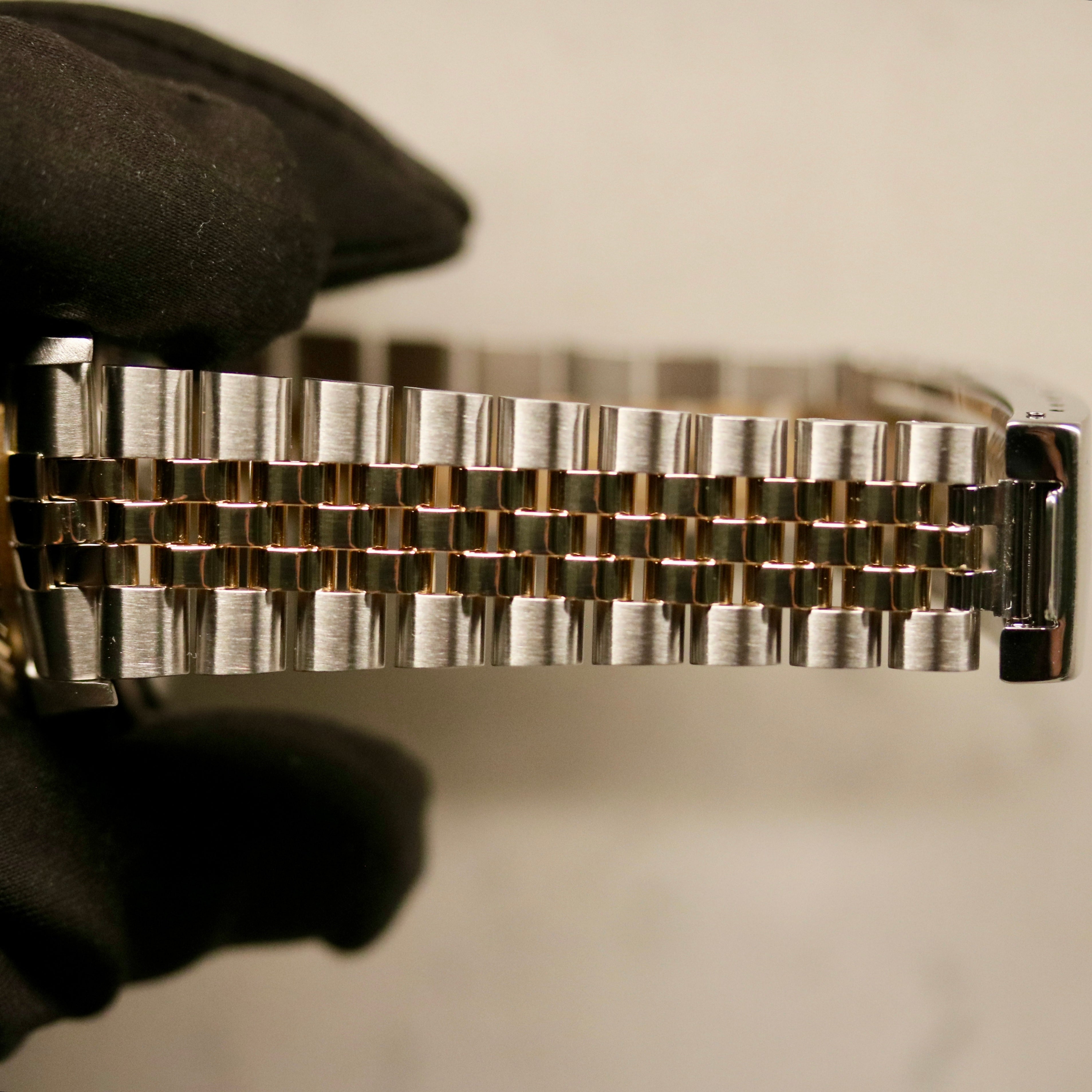 Rolex Datejust 36 ref. 16233 from 2003 in two-tone steel and yellow gold with a champagne Roman numeral dial, 36mm case, Jubilee bracelet, sapphire crystal, and automatic movement. Detailed product photos showing the fluted yellow-gold bezel, Roman hour markers, bracelet links, clasp, and overall condition. Includes original Hong Kong 2003 certificate, box, and tag, offered by Klocksalongen with a 12-month functional warranty.