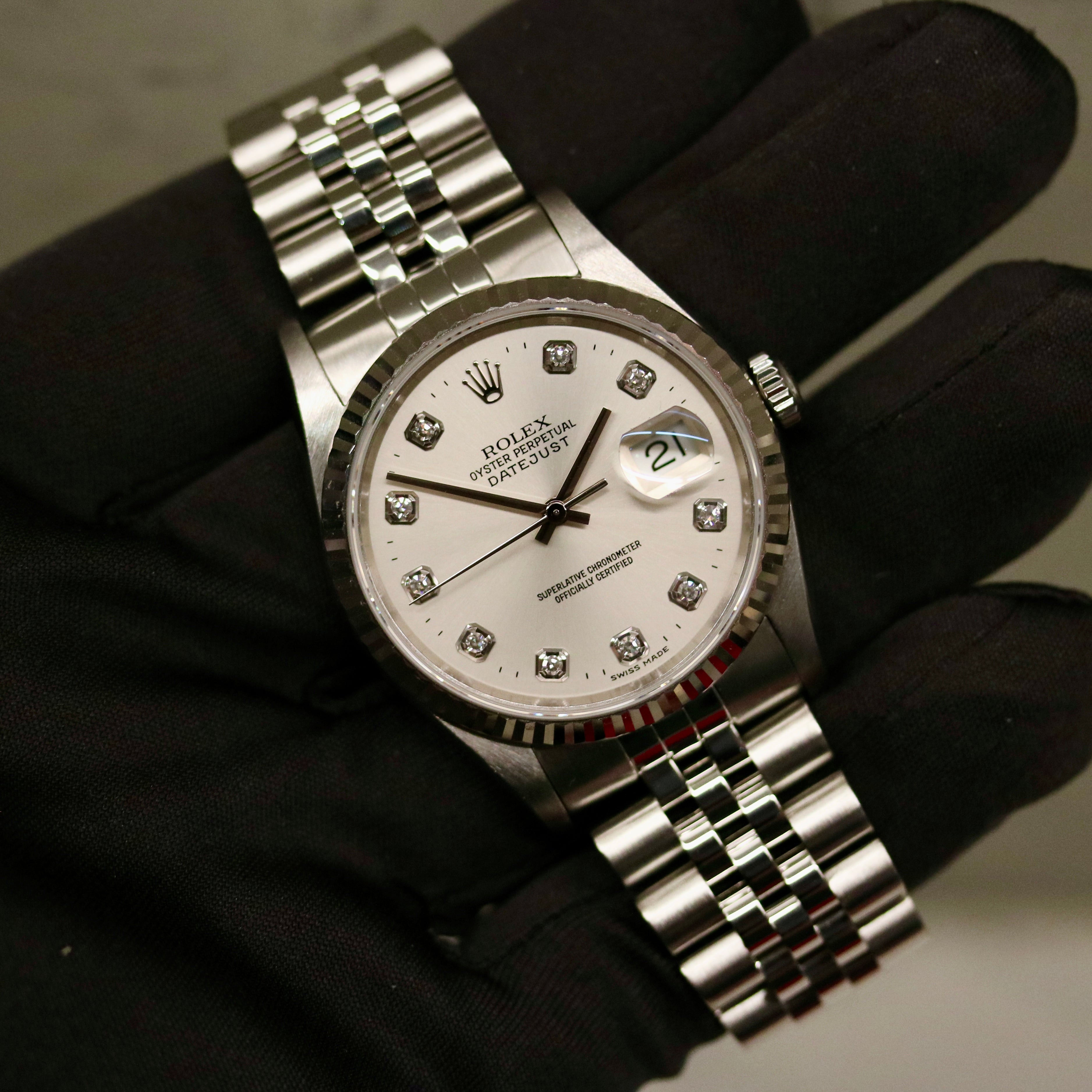 Rolex Datejust 36 ref. 16234 from 2000 with a white-gold fluted bezel and stainless-steel case and bracelet, featuring a factory silver diamond dial, sapphire crystal, automatic movement, and very good condition; detailed product images showing the dial, bezel, bracelet, case profile, and finishing, offered by Klocksalongen with recent polishing and 12-month functional warranty.