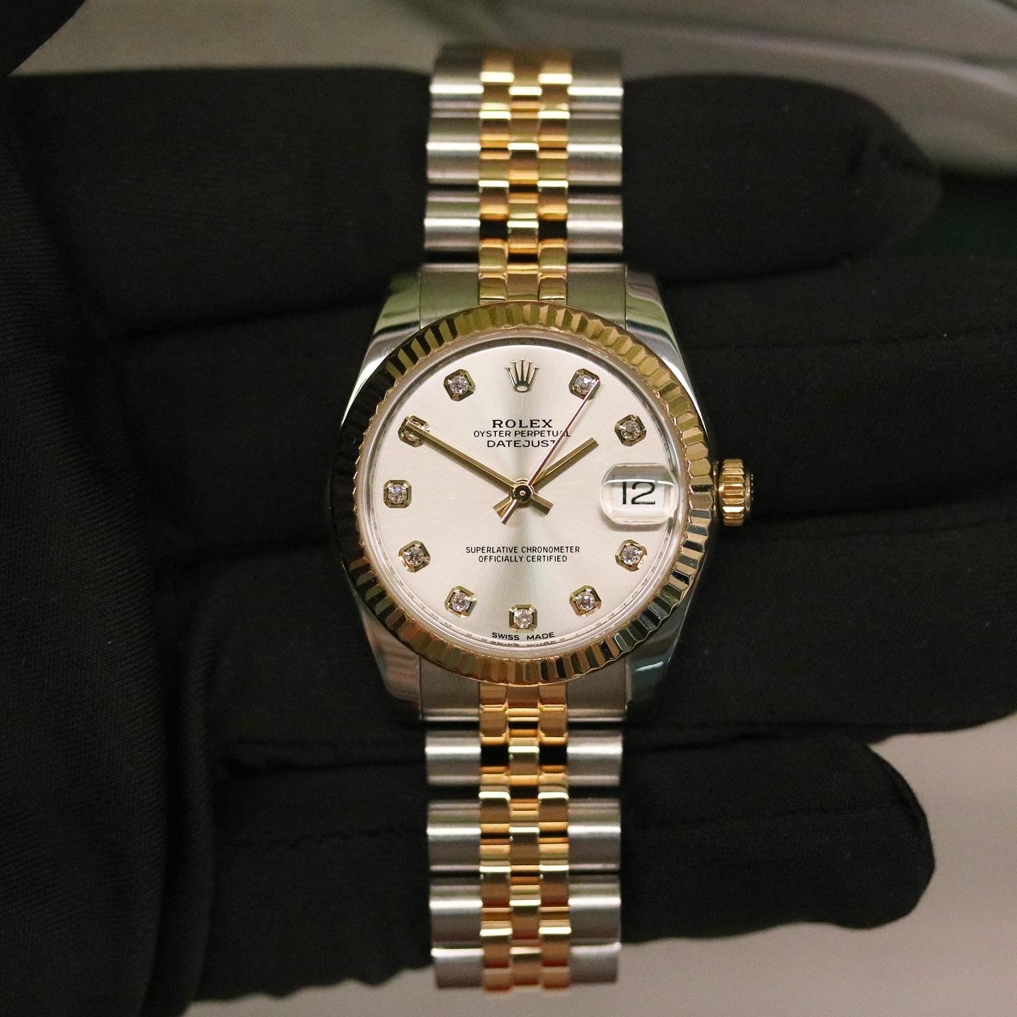 Rolex Datejust 31 ref. 178273 from 2012 in two-tone stainless steel and yellow gold with a factory silver diamond dial, 31mm case, Jubilee bracelet, sapphire crystal, and automatic movement. Presented in very good condition with original 2012 Netherlands certificate, box, tags, certificate holder, and booklets. Detailed product photos show the diamond markers, fluted bezel, case, bracelet, and clasp, offered by Klocksalongen with a 12-month functional warranty.