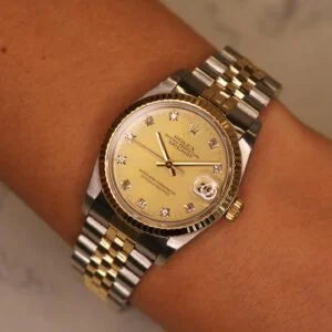 Rolex Datejust 31 ref. 68273 from 1989 in two-tone stainless steel and yellow gold with a factory champagne diamond dial, 31mm case, Jubilee bracelet, sapphire crystal, and automatic movement. Freshly serviced and polished, in very good condition. Complete full set including original 1989 USA certificate, box, booklets, and tag. Detailed product photos showing the diamond-set dial, fluted bezel, case, bracelet, and clasp, offered by Klocksalongen with a 12-month service warranty.