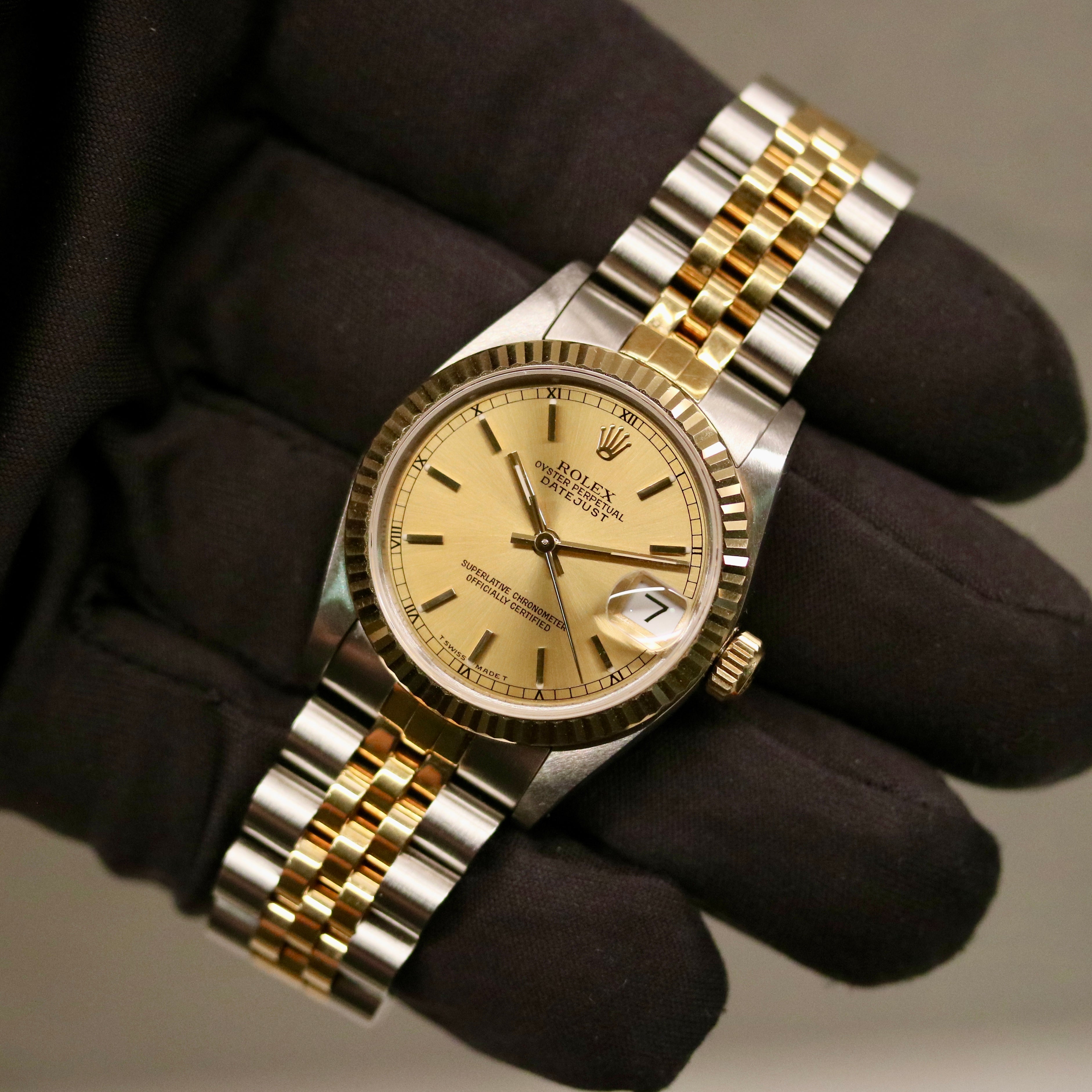 Rolex Datejust 31 ref. 68273 from 1990 in two-tone stainless steel and yellow gold with a factory silver diamond dial, 31mm case, Jubilee bracelet, sapphire crystal, and automatic movement. Unpolished example in extremely good condition with original Spain certificate, box, booklets, and tag. Detailed product photos showing the dial, diamond markers, bezel, case, bracelet, and clasp, available from Klocksalongen with a 12-month functional warranty.