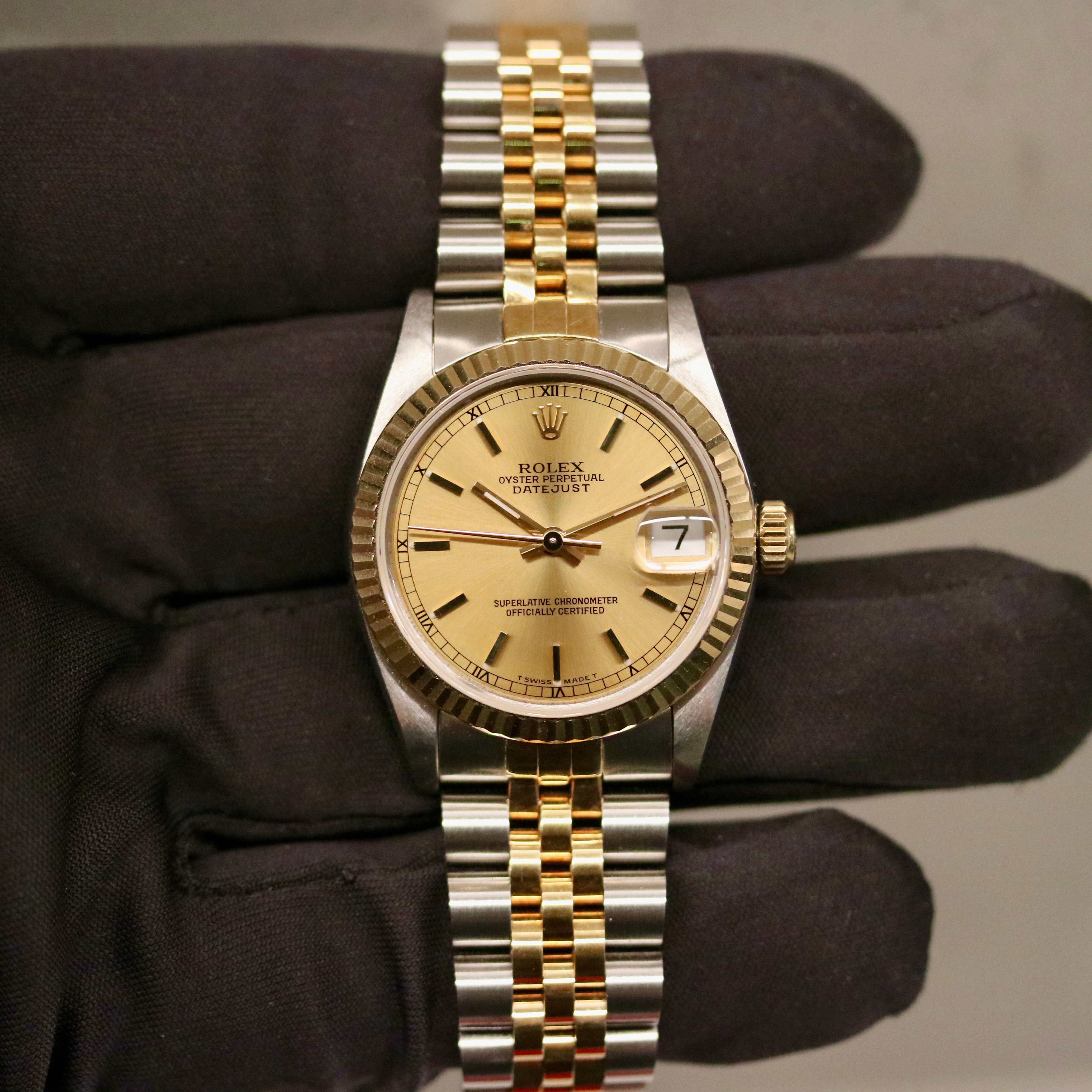 Rolex Datejust 31 ref. 68273 from 1990 in two-tone stainless steel and yellow gold with a factory silver diamond dial, 31mm case, Jubilee bracelet, sapphire crystal, and automatic movement. Unpolished example in extremely good condition with original Spain certificate, box, booklets, and tag. Detailed product photos showing the dial, diamond markers, bezel, case, bracelet, and clasp, available from Klocksalongen with a 12-month functional warranty.