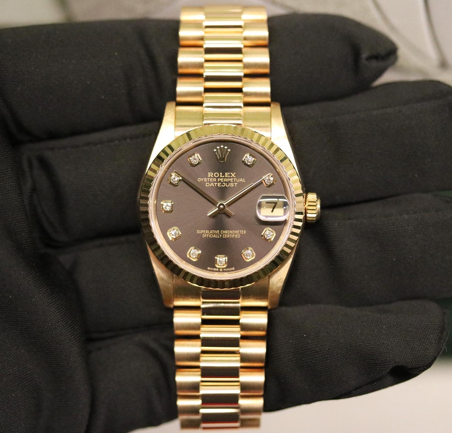 Rolex Datejust 31 ref. 68278 from 1989 in solid yellow gold with a rare factory chocolate/dark grey diamond dial (2020 version), 31mm case, President bracelet, sapphire crystal, and automatic movement. Presented in superb condition and complete with original Italy 1989 certificate, box, booklets, and tag. Detailed photos showing the upgraded dial, diamond markers, gold bezel, case, bracelet, and clasp, offered by Klocksalongen with a 12-month functional warranty.