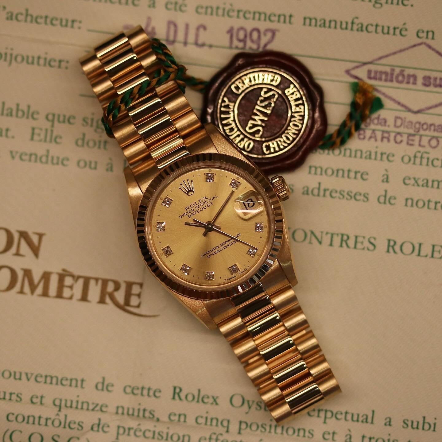 Rolex Datejust 31 ref. 68278 from 1992 in solid yellow gold with a factory champagne diamond dial, 31mm case, President bracelet, sapphire crystal, and automatic movement. Top-condition example, complete with original Spain 1992 certificate, box, booklets, and tag. Detailed product images showing the champagne diamond dial, gold bezel, case, bracelet links, and clasp, offered by Klocksalongen with a 12-month functional warranty.