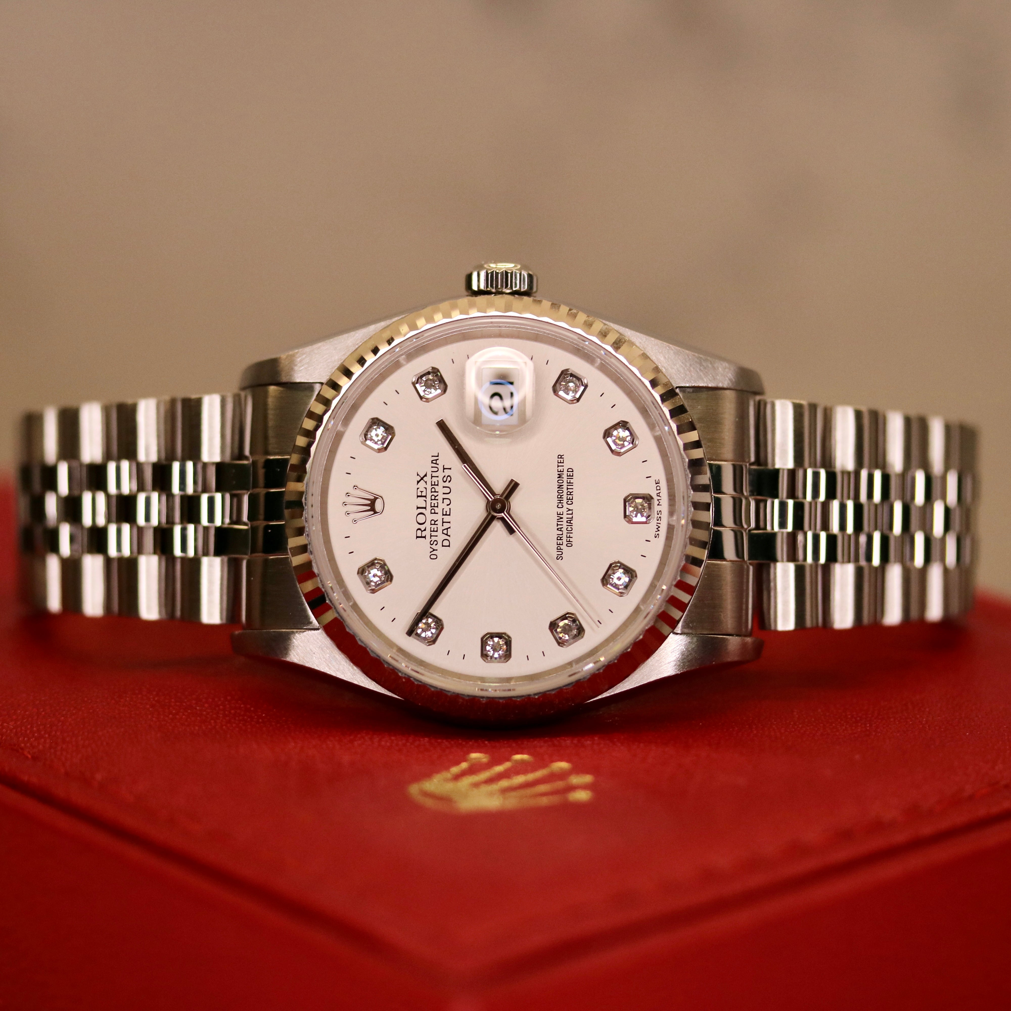 Rolex Datejust 36 ref. 16234 from 2000 with a white-gold fluted bezel and stainless-steel case and bracelet, featuring a factory silver diamond dial, sapphire crystal, automatic movement, and very good condition; detailed product images showing the dial, bezel, bracelet, case profile, and finishing, offered by Klocksalongen with recent polishing and 12-month functional warranty.
