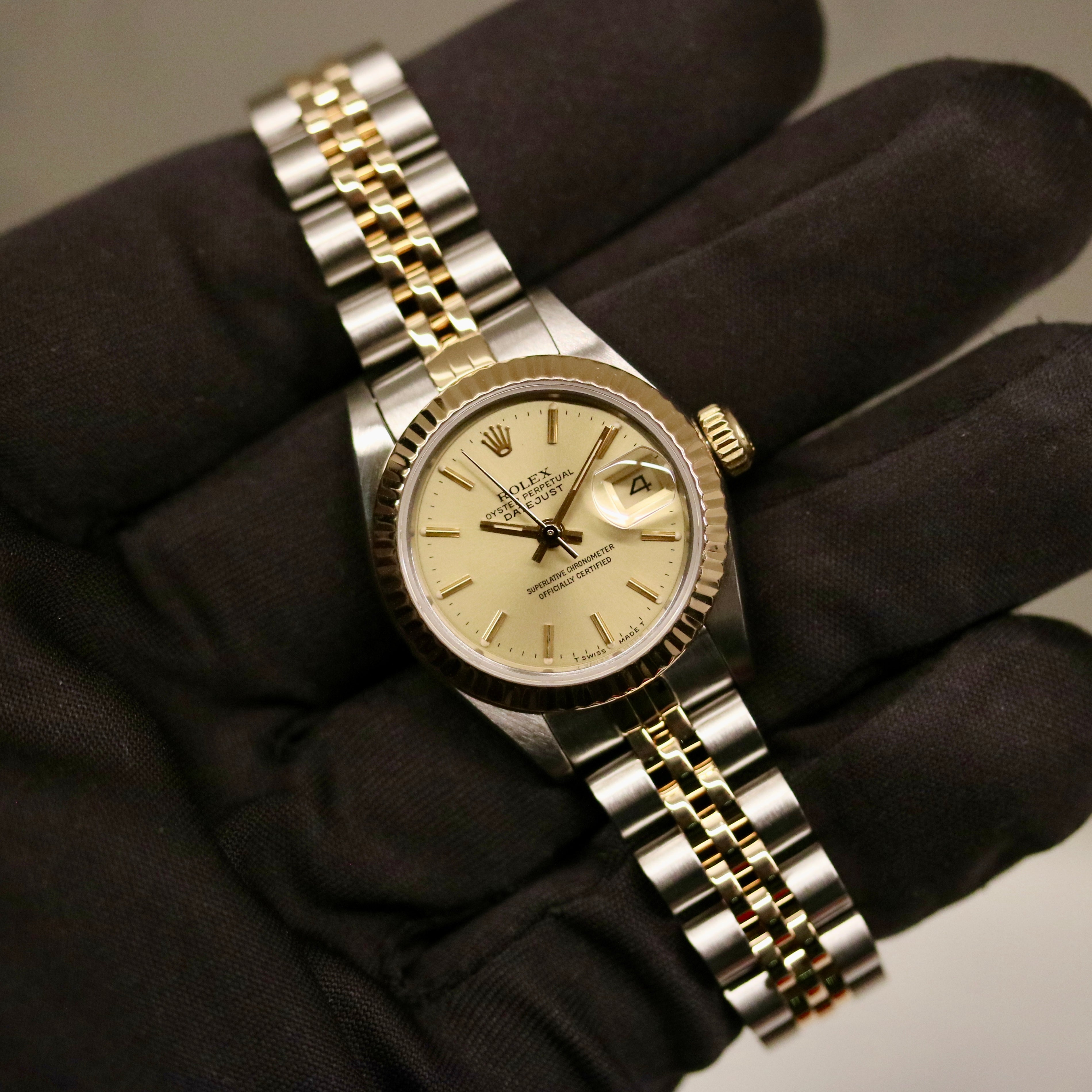 Rolex Lady-Datejust 26 ref. 69173 from 1986 in two-tone stainless steel and yellow gold with a champagne dial, 26mm case, Jubilee bracelet, sapphire crystal, and automatic movement. Recently polished and presented in good condition with Klocksalongen authenticity certificate and packaging. Detailed photos show the champagne dial, gold fluted bezel, case, bracelet, and clasp, offered with a 12-month functional warranty.