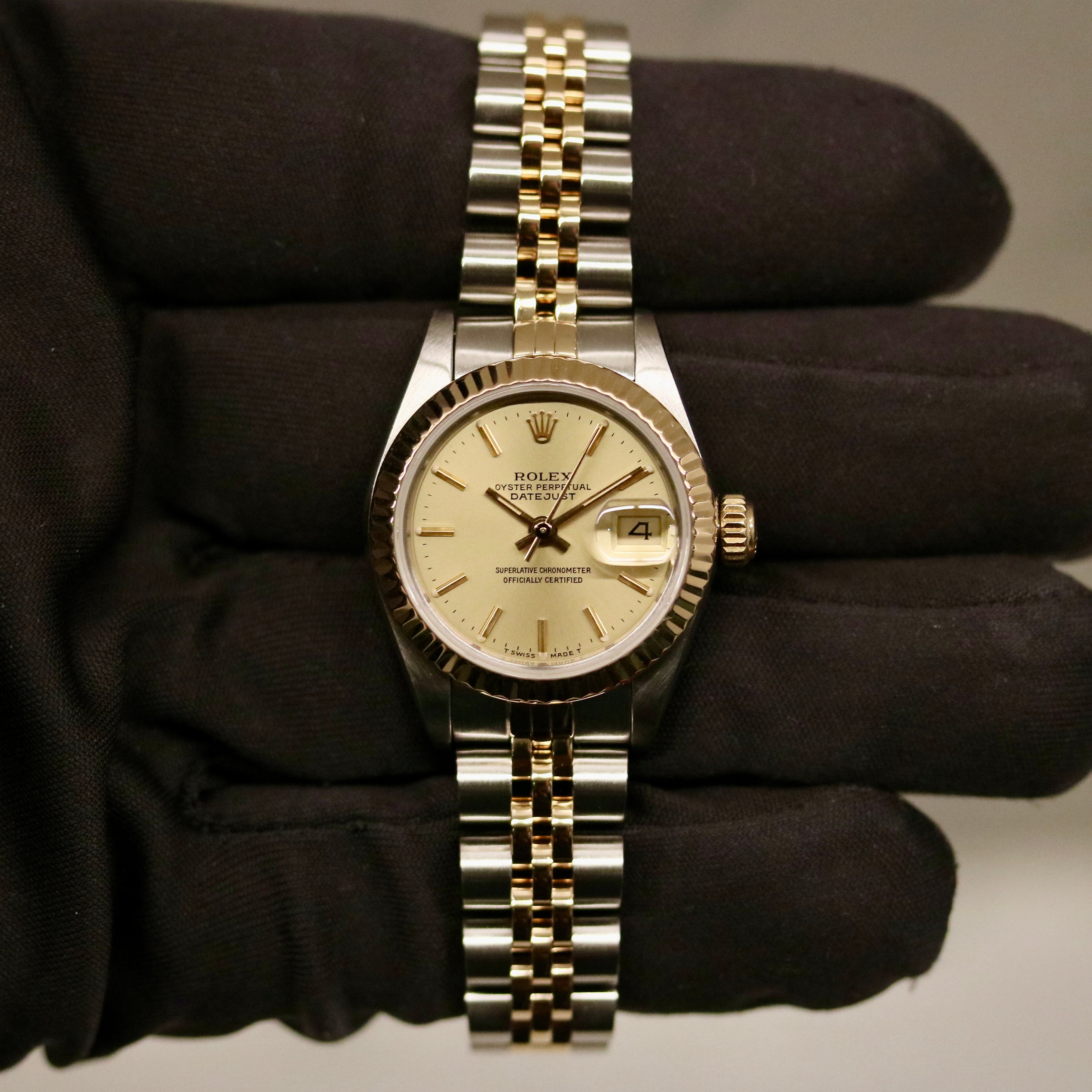 Rolex Lady-Datejust 26 ref. 69173 from 1986 in two-tone stainless steel and yellow gold with a champagne dial, 26mm case, Jubilee bracelet, sapphire crystal, and automatic movement. Recently polished and presented in good condition with Klocksalongen authenticity certificate and packaging. Detailed photos show the champagne dial, gold fluted bezel, case, bracelet, and clasp, offered with a 12-month functional warranty.