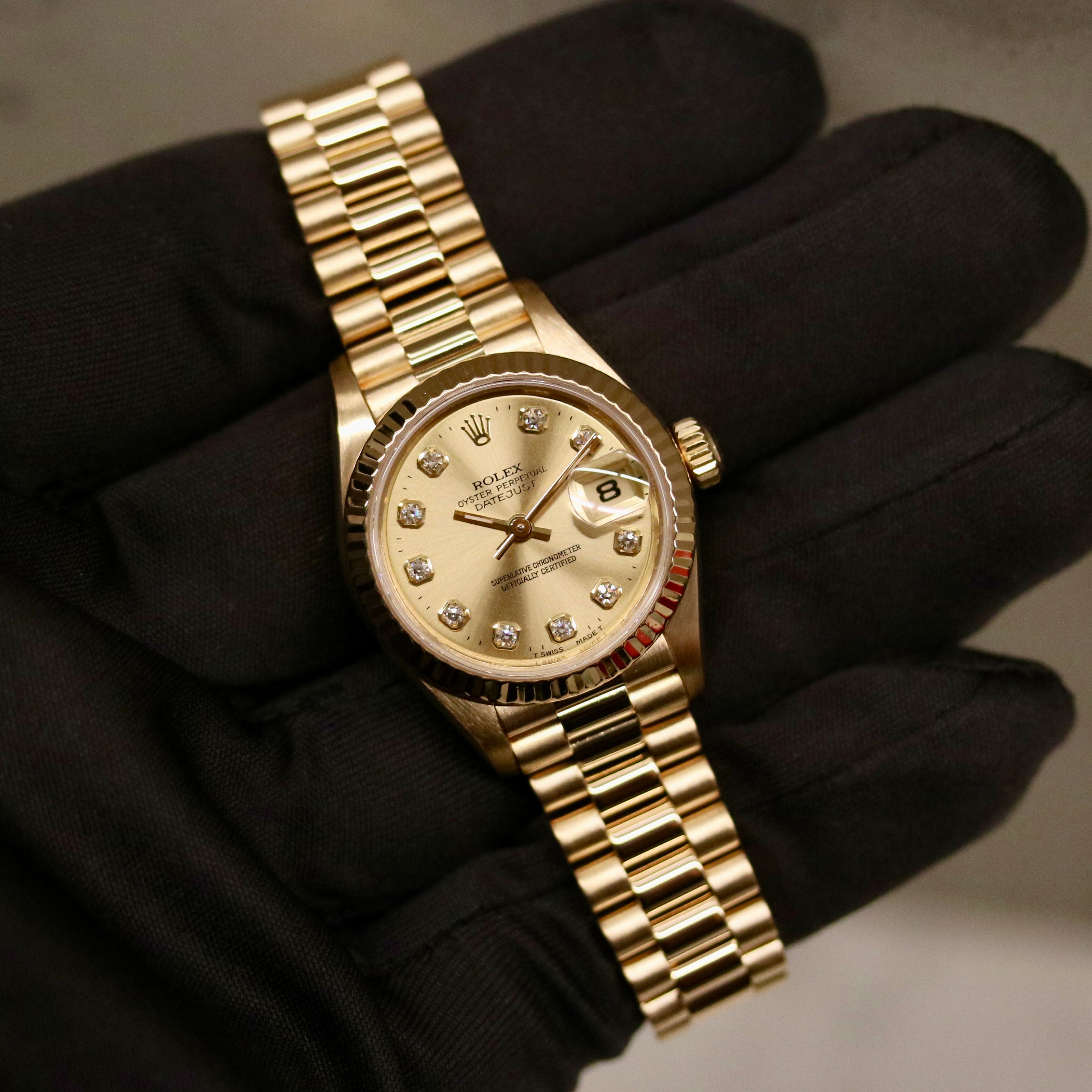 Rolex Lady-Datejust 26 ref. 69178 from 1996 in solid yellow gold with a factory champagne diamond dial, 26mm case, President bracelet, sapphire crystal, and automatic movement. Includes original Japan certificate, box, and tag. Detailed product photos showing the dial, diamonds, case, bracelet, clasp, and overall very good condition, offered by Klocksalongen with a 12-month functional warranty.