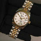 Rolex Datejust 31 ref. 178273 from 2012 in two-tone stainless steel and yellow gold with a factory silver diamond dial, 31mm case, Jubilee bracelet, sapphire crystal, and automatic movement. Presented in very good condition with original 2012 Netherlands certificate, box, tags, certificate holder, and booklets. Detailed product photos show the diamond markers, fluted bezel, case, bracelet, and clasp, offered by Klocksalongen with a 12-month functional warranty.