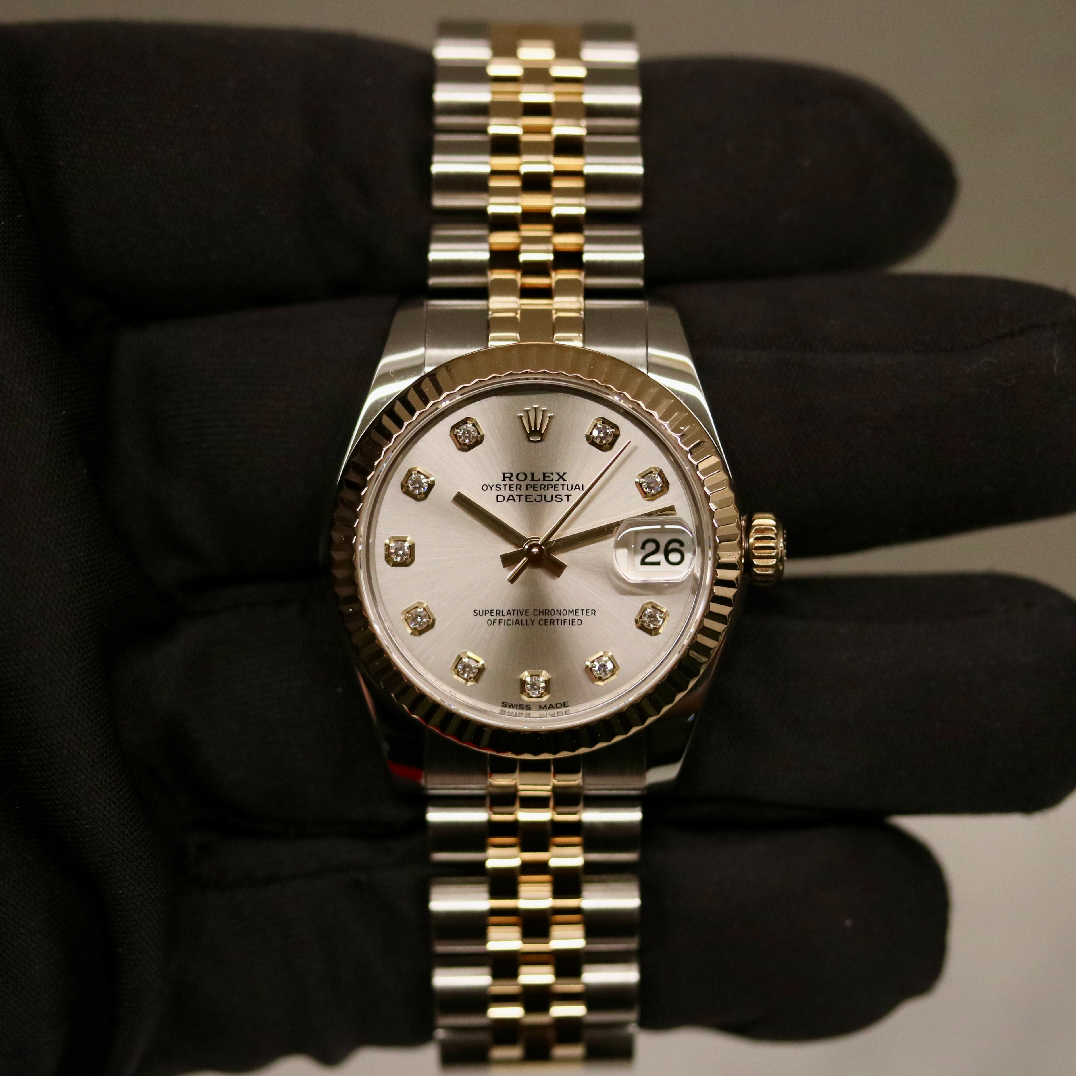 Rolex Datejust 31 ref. 178273 from 2018 in two-tone stainless steel and yellow gold with a factory silver diamond dial, 31mm case, Jubilee bracelet, sapphire crystal, and automatic movement. Presented in very good condition with original Egypt 2018 certificate, box, booklets, and tags. Includes photos detailing the diamond dial, fluted bezel, bracelet, case, and clasp, offered by Klocksalongen with a 12-month functional warranty.