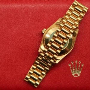 Rolex Datejust 31 ref. 68238 from 2000 in solid yellow gold with factory diamond-set bezel and a factory champagne big diamond dial, 31mm case, President bracelet, sapphire crystal, and automatic movement. Excellent condition, freshly serviced, and complete with original 2000 Spain certificate, box, booklets, and tag. Detailed product photos showing the diamond bezel, large diamond markers, gold case, bracelet, clasp, and finishing, offered by Klocksalongen with a 12-month service warranty.