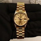 Rolex Datejust 31 ref. 68238 from 2000 in solid yellow gold with factory diamond-set bezel and a factory champagne big diamond dial, 31mm case, President bracelet, sapphire crystal, and automatic movement. Excellent condition, freshly serviced, and complete with original 2000 Spain certificate, box, booklets, and tag. Detailed product photos showing the diamond bezel, large diamond markers, gold case, bracelet, clasp, and finishing, offered by Klocksalongen with a 12-month service warranty.