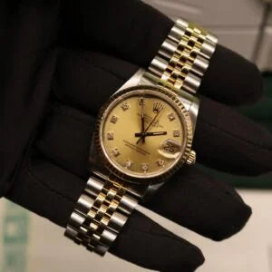Rolex Datejust 31 ref. 68273 from 1989 in two-tone stainless steel and yellow gold with a factory champagne diamond dial, 31mm case, Jubilee bracelet, sapphire crystal, and automatic movement. Freshly serviced and polished, in very good condition. Complete full set including original 1989 USA certificate, box, booklets, and tag. Detailed product photos showing the diamond-set dial, fluted bezel, case, bracelet, and clasp, offered by Klocksalongen with a 12-month service warranty.