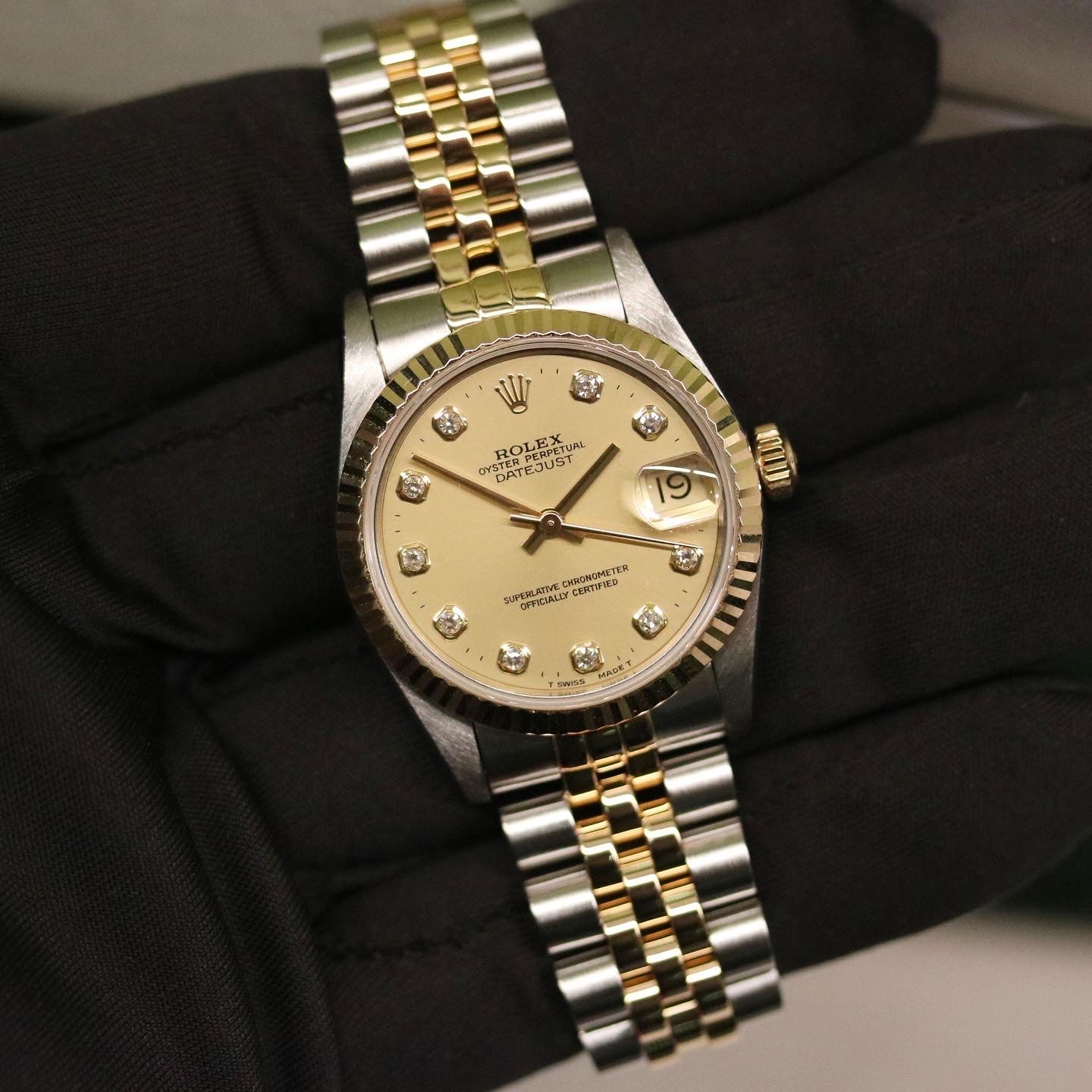Rolex Datejust 31 ref. 68273 from 1999 in two-tone stainless steel and yellow gold with a factory champagne diamond dial, 31mm case, Jubilee bracelet, sapphire crystal, and automatic movement. Recently serviced and polished, delivered in very good condition with original Japan 1999 certificate, box, booklets, and tag. Detailed product images show the diamond-set dial, fluted bezel, case, bracelet, clasp, and finishing, offered by Klocksalongen with a 12-month service warranty.