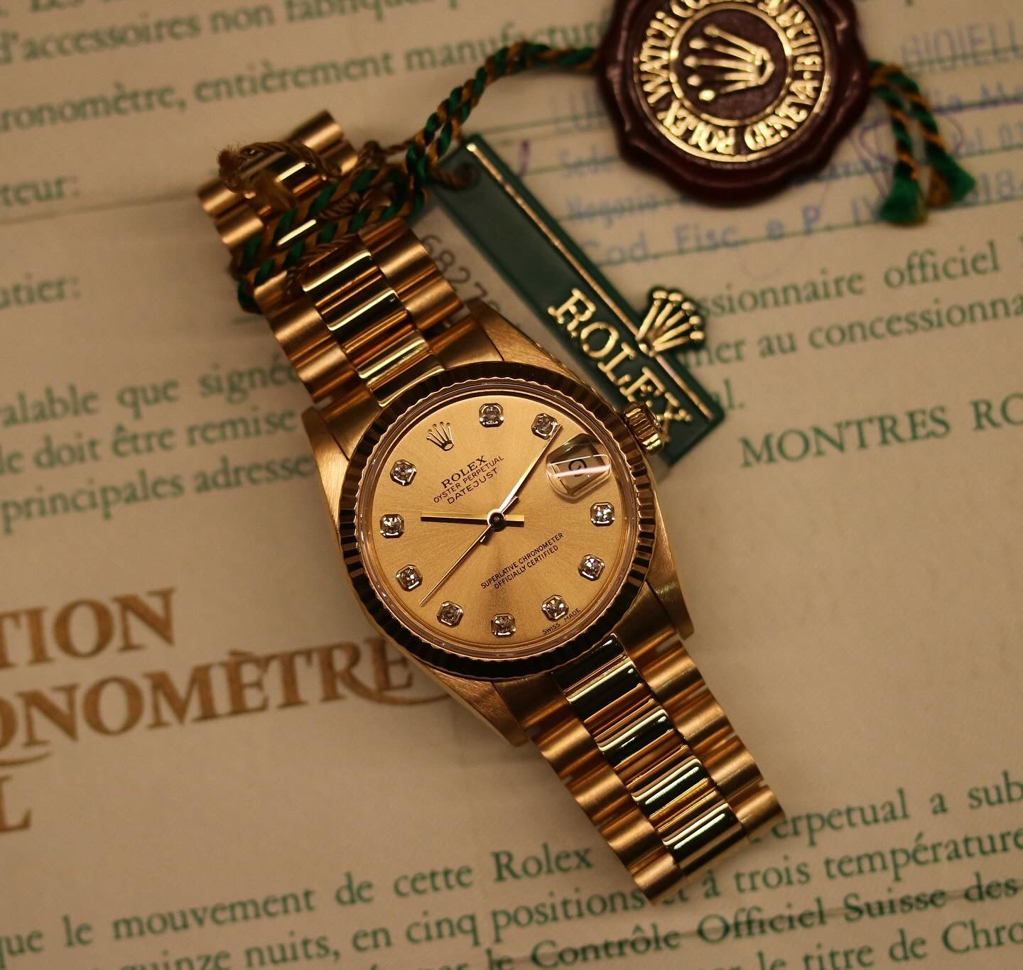 Rolex Datejust 31 ref. 68278 from 1987 in solid yellow gold with a factory champagne diamond dial, 31mm case, President bracelet, sapphire crystal, and automatic movement. Presented in very good condition and complete with original 1987 Italian certificate, box, booklets, and tags. Detailed product photos showing the diamond dial, gold case, bracelet, clasp, and overall finish, available from Klocksalongen with a 12-month functional warranty.