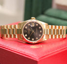 Rolex Datejust 31 ref. 68278 from 1989 in solid yellow gold with a rare factory chocolate/dark grey diamond dial (2020 version), 31mm case, President bracelet, sapphire crystal, and automatic movement. Presented in superb condition and complete with original Italy 1989 certificate, box, booklets, and tag. Detailed photos showing the upgraded dial, diamond markers, gold bezel, case, bracelet, and clasp, offered by Klocksalongen with a 12-month functional warranty.