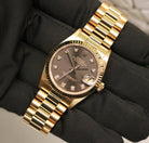 Rolex Datejust 31 ref. 68278 from 1989 in solid yellow gold with a rare factory chocolate/dark grey diamond dial (2020 version), 31mm case, President bracelet, sapphire crystal, and automatic movement. Presented in superb condition and complete with original Italy 1989 certificate, box, booklets, and tag. Detailed photos showing the upgraded dial, diamond markers, gold bezel, case, bracelet, and clasp, offered by Klocksalongen with a 12-month functional warranty.