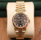 Rolex Datejust 31 ref. 68278 from 1989 in solid yellow gold with a rare factory chocolate/dark grey diamond dial (2020 version), 31mm case, President bracelet, sapphire crystal, and automatic movement. Presented in superb condition and complete with original Italy 1989 certificate, box, booklets, and tag. Detailed photos showing the upgraded dial, diamond markers, gold bezel, case, bracelet, and clasp, offered by Klocksalongen with a 12-month functional warranty.