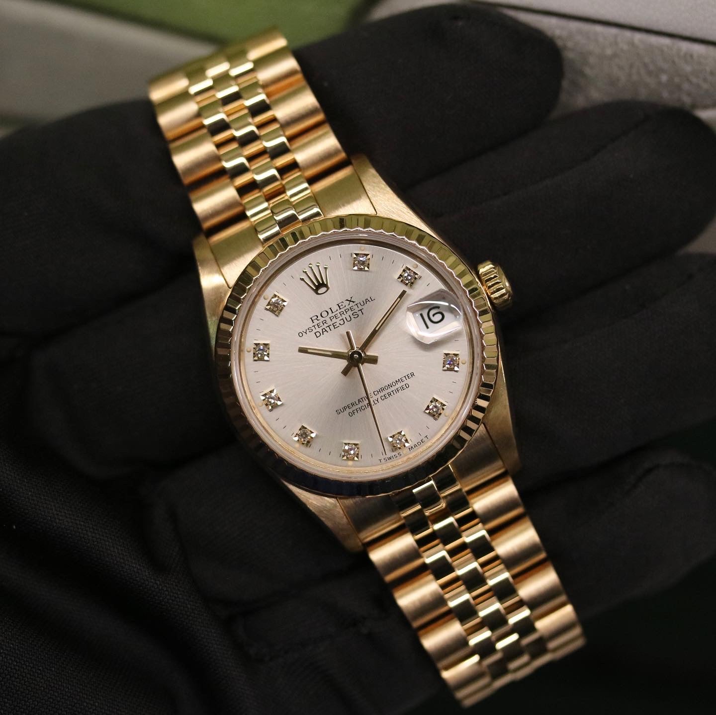 Rolex Datejust 31 ref. 68278 from 1991 in solid yellow gold with a factory silver diamond dial, 31mm case, President bracelet, sapphire crystal, and automatic movement. Presented in very good condition with Klocksalongen authenticity certificate and packaging. Detailed product photos showing the diamond-set dial, gold case, bracelet, clasp, and overall finish, offered with a 12-month functional warranty.