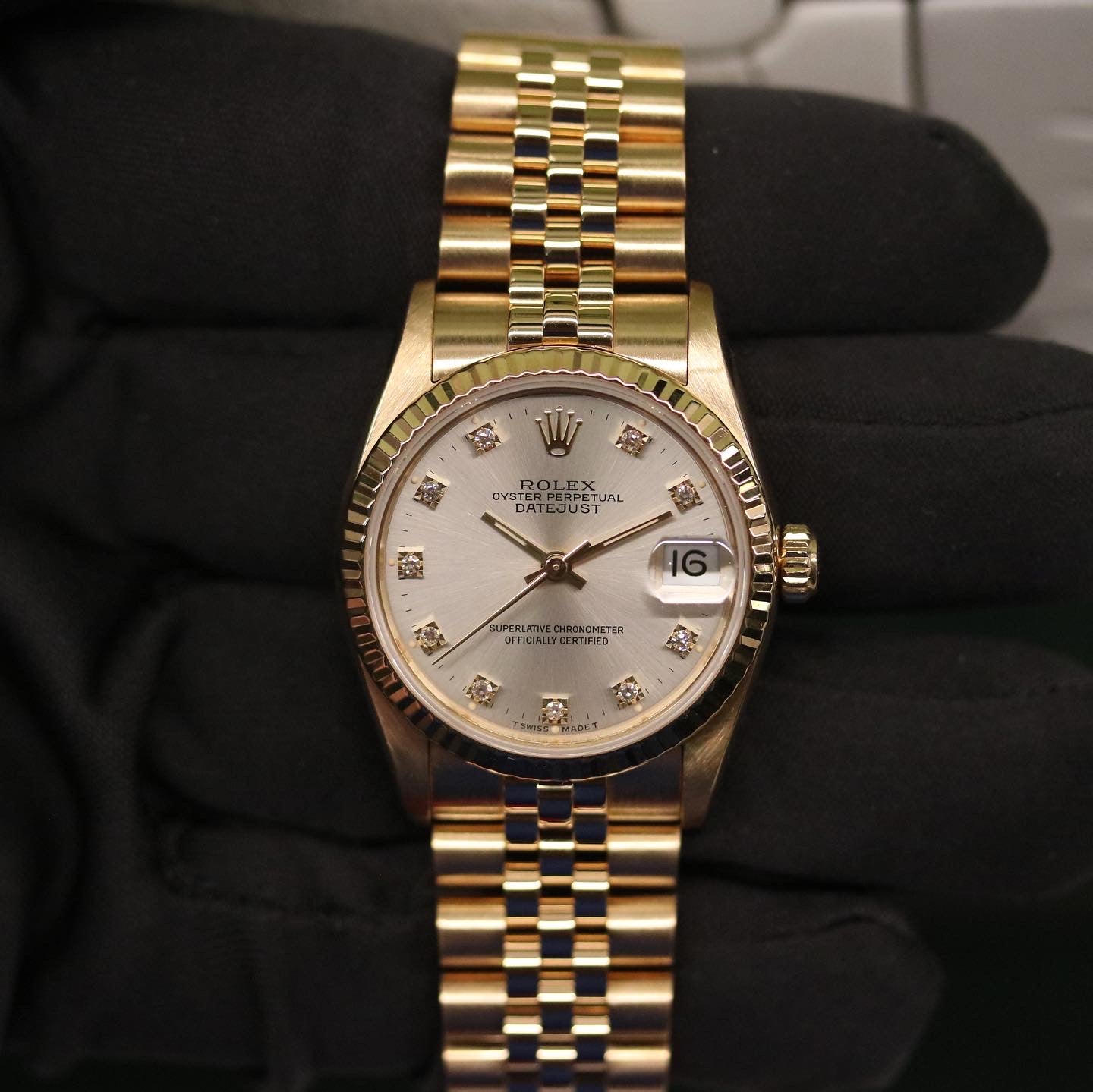 Rolex Datejust 31 ref. 68278 from 1991 in solid yellow gold with a factory silver diamond dial, 31mm case, President bracelet, sapphire crystal, and automatic movement. Presented in very good condition with Klocksalongen authenticity certificate and packaging. Detailed product photos showing the diamond-set dial, gold case, bracelet, clasp, and overall finish, offered with a 12-month functional warranty.