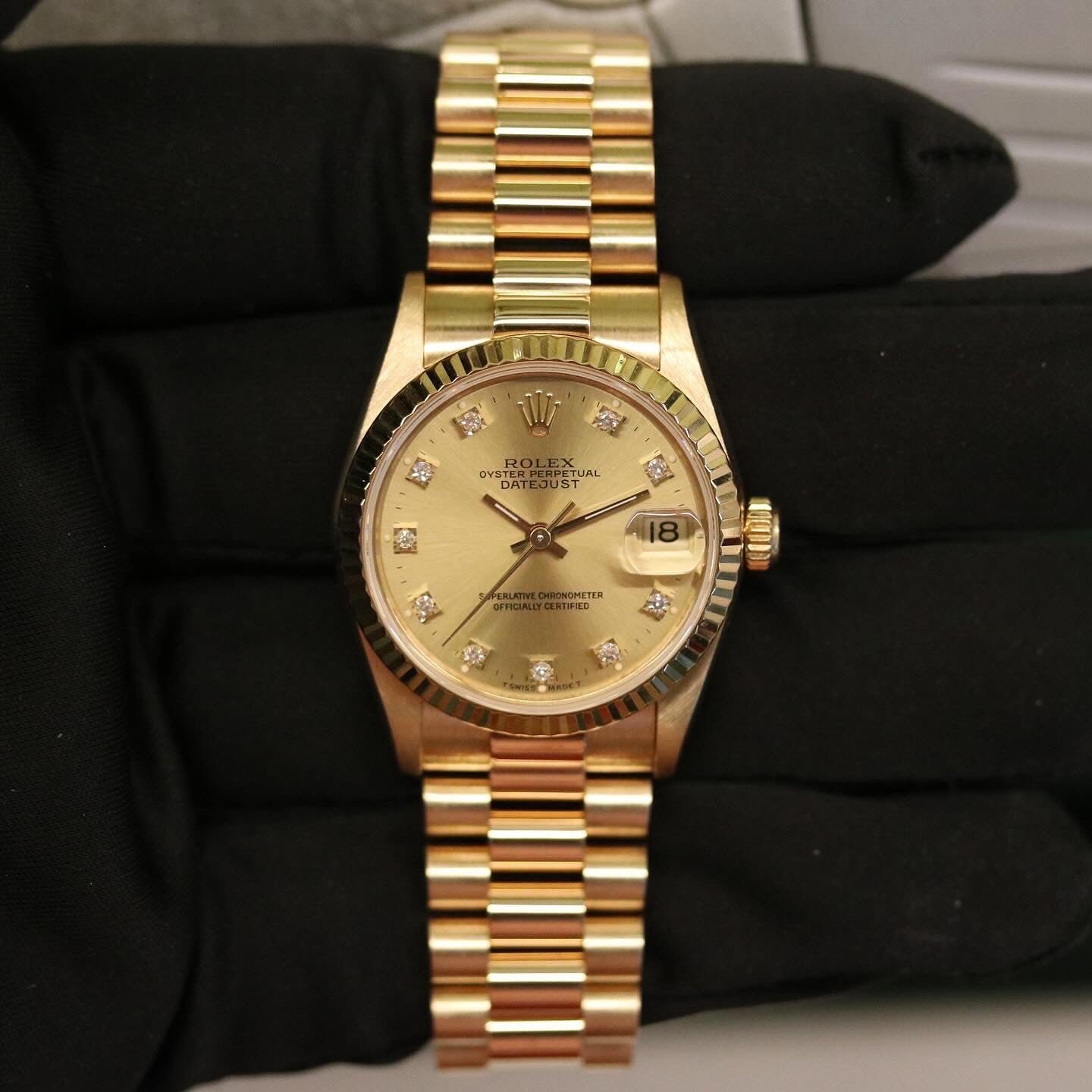 Rolex Datejust 31 ref. 68278 from 1992 in solid yellow gold with a factory champagne diamond dial, 31mm case, President bracelet, sapphire crystal, and automatic movement. Top-condition example, complete with original Spain 1992 certificate, box, booklets, and tag. Detailed product images showing the champagne diamond dial, gold bezel, case, bracelet links, and clasp, offered by Klocksalongen with a 12-month functional warranty.