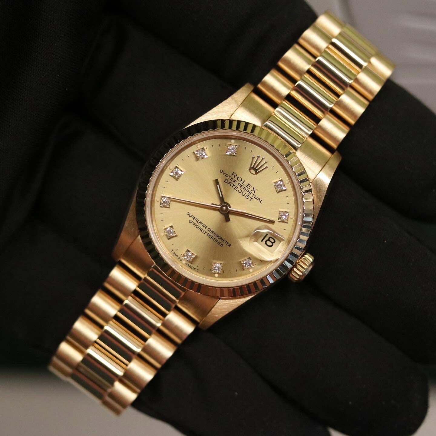 Rolex Datejust 31 ref. 68278 from 1992 in solid yellow gold with a factory champagne diamond dial, 31mm case, President bracelet, sapphire crystal, and automatic movement. Top-condition example, complete with original Spain 1992 certificate, box, booklets, and tag. Detailed product images showing the champagne diamond dial, gold bezel, case, bracelet links, and clasp, offered by Klocksalongen with a 12-month functional warranty.