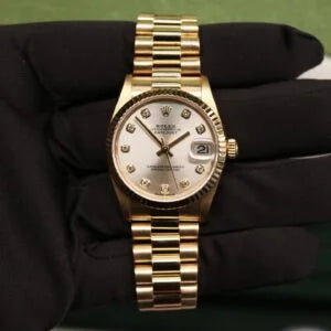 Rolex Datejust 31 ref. 78278 from 1999 in solid yellow gold with a factory silver big diamond dial, 31mm case, President bracelet, sapphire crystal, and automatic movement. Very good condition, freshly serviced and polished, accompanied by a Rolex pouch and Klocksalongen authenticity certificate. Detailed product images showing the large diamond hour markers, gold case, bracelet, clasp, and overall finishing, offered by Klocksalongen with a 12-month service warranty.