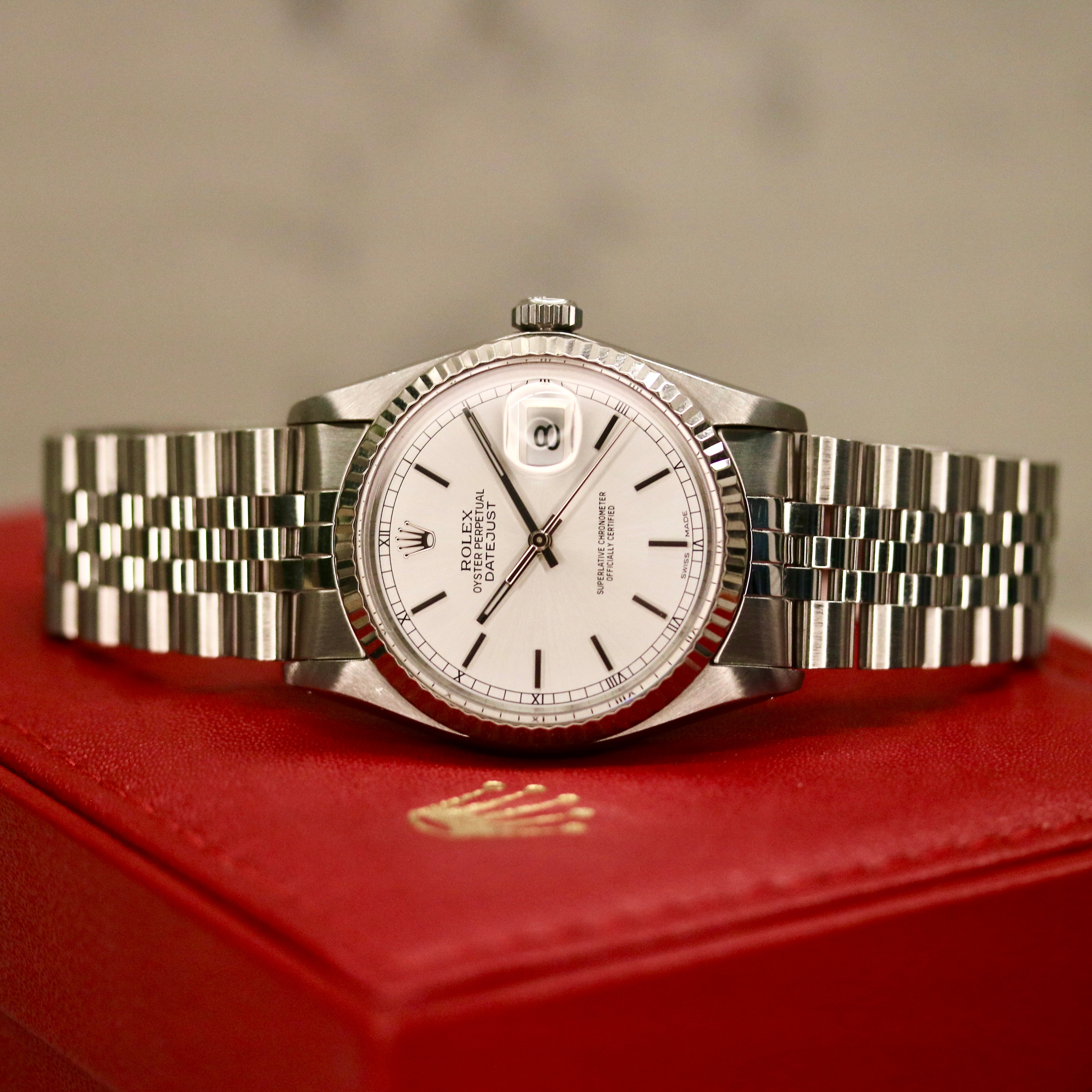 Rolex Datejust 36 ref. 16014 from 1984 with a white-gold fluted bezel and stainless-steel case and bracelet, featuring a silver dial, sapphire crystal, automatic movement, and very good condition; detailed product photos showing the dial, bezel, case profile, bracelet, and overall finishing, offered by Klocksalongen with authenticity certificate and 12-month functional warranty.