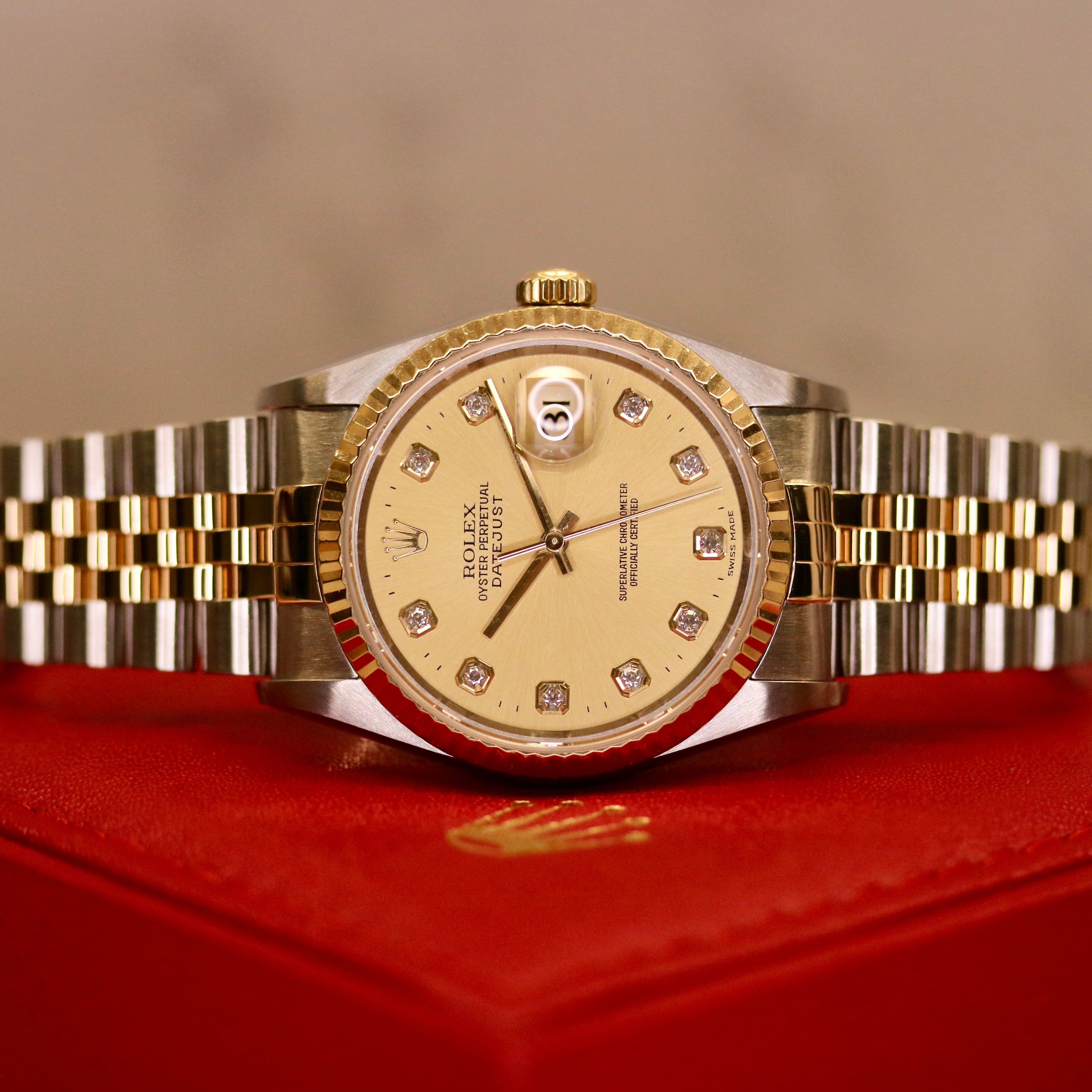 Rolex Datejust 36 ref. 16233 from 2003 in steel and yellow gold with a factory champagne diamond dial, 36mm case, Jubilee bracelet, sapphire crystal, and automatic movement. Close-up product images showing the diamond hour markers, two-tone case and bracelet, fluted yellow-gold bezel, clasp, and overall condition. Includes original South Korea certificate (2003), box, and tag, offered by Klocksalongen with a 12-month functional warranty.