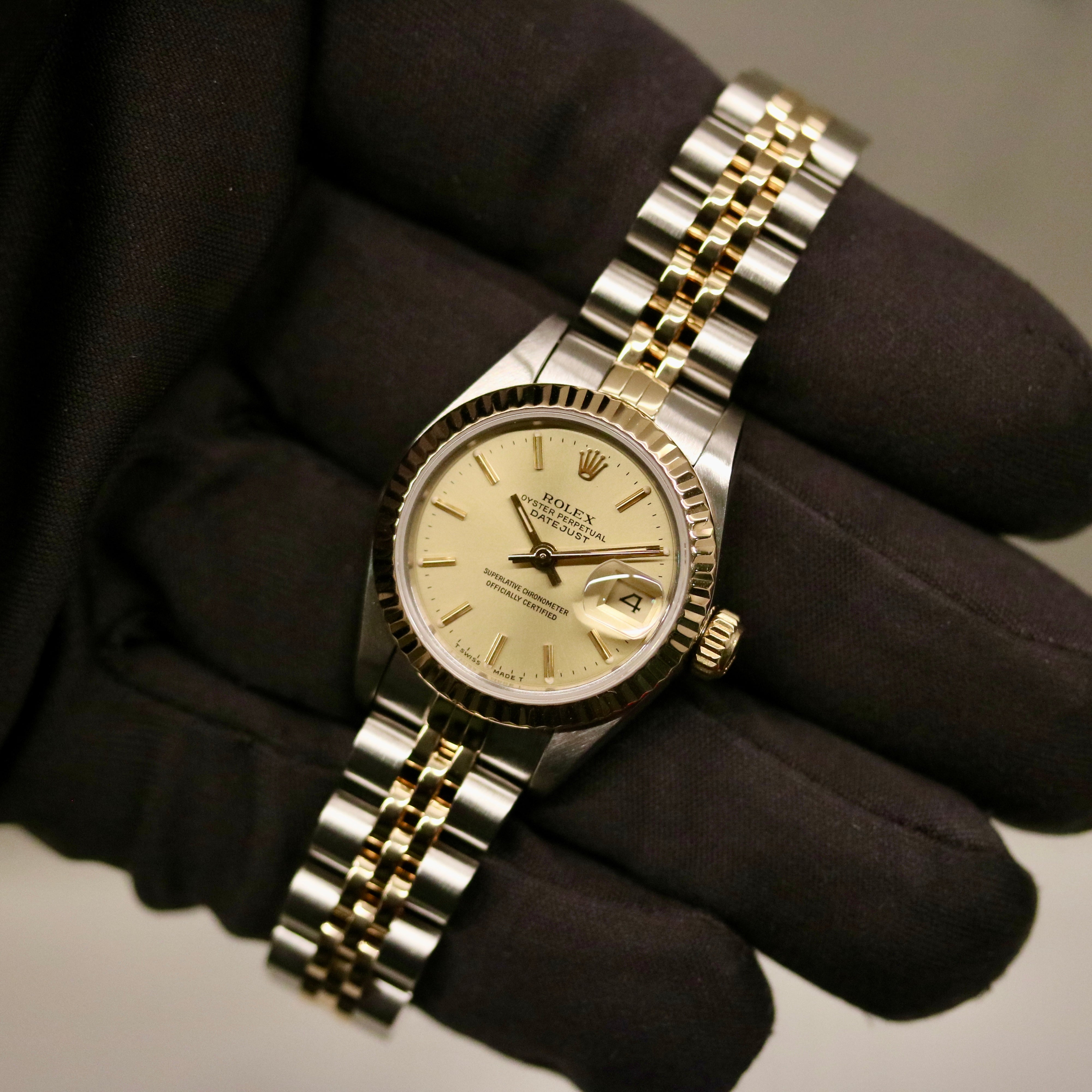 Rolex Lady-Datejust 26 ref. 69173 from 1986 in two-tone stainless steel and yellow gold with a champagne dial, 26mm case, Jubilee bracelet, sapphire crystal, and automatic movement. Recently polished and presented in good condition with Klocksalongen authenticity certificate and packaging. Detailed photos show the champagne dial, gold fluted bezel, case, bracelet, and clasp, offered with a 12-month functional warranty.