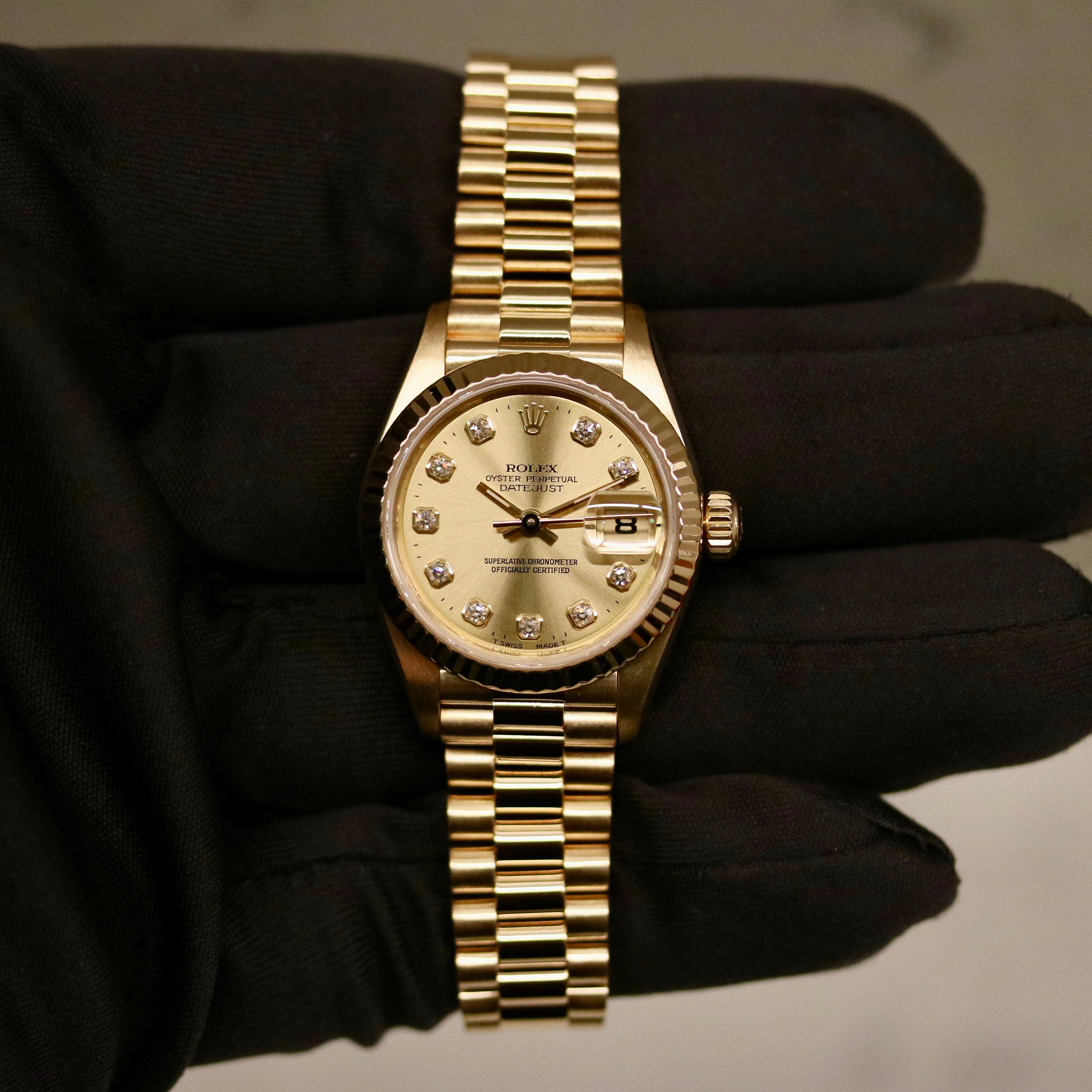 Rolex Lady-Datejust 26 ref. 69178 from 1996 in solid yellow gold with a factory champagne diamond dial, 26mm case, President bracelet, sapphire crystal, and automatic movement. Includes original Japan certificate, box, and tag. Detailed product photos showing the dial, diamonds, case, bracelet, clasp, and overall very good condition, offered by Klocksalongen with a 12-month functional warranty.