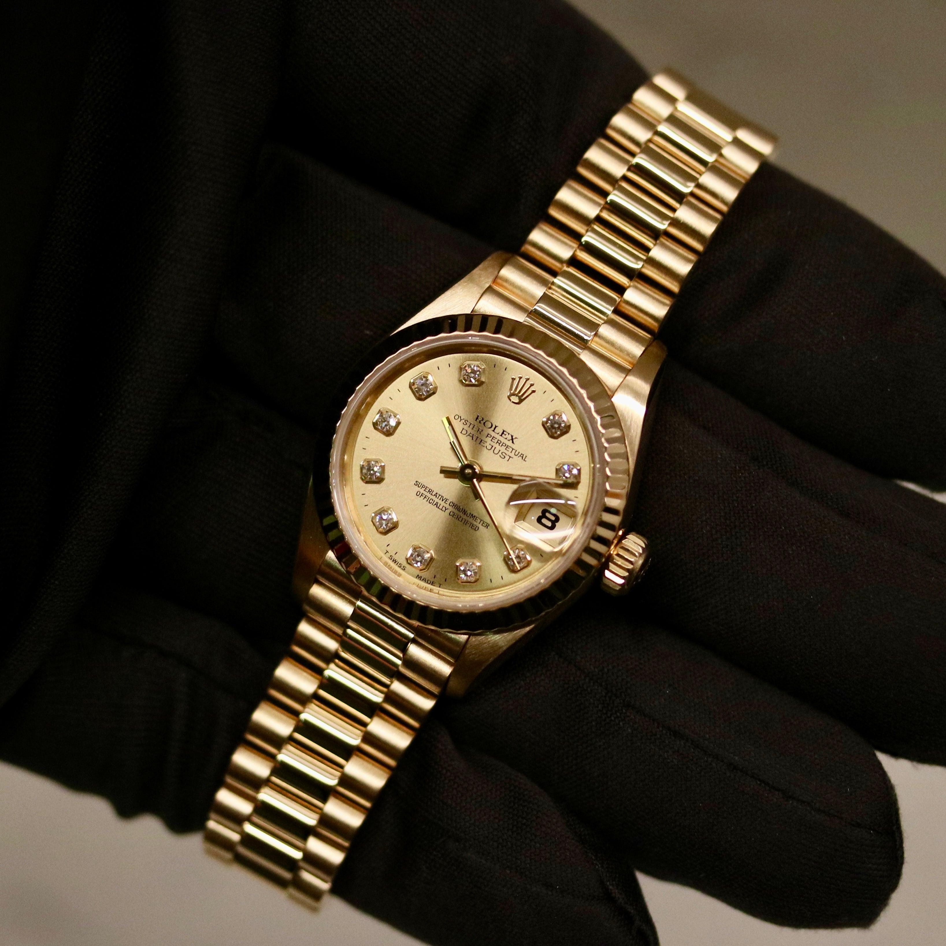 Rolex Lady-Datejust 26 ref. 69178 from 1996 in solid yellow gold with a factory champagne diamond dial, 26mm case, President bracelet, sapphire crystal, and automatic movement. Includes original Japan certificate, box, and tag. Detailed product photos showing the dial, diamonds, case, bracelet, clasp, and overall very good condition, offered by Klocksalongen with a 12-month functional warranty.